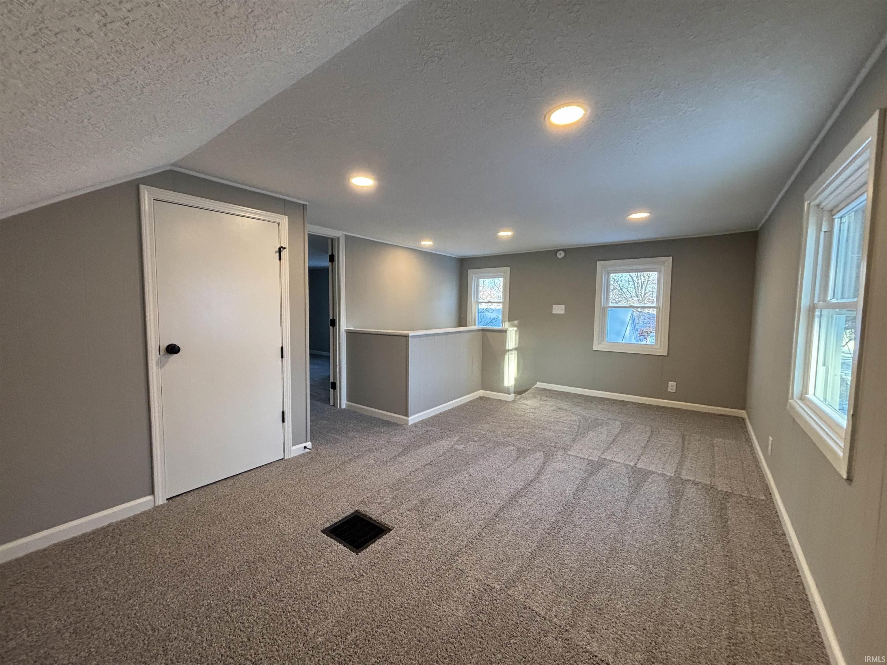 Spare room with a textured ceiling, carpet, and recessed lighting