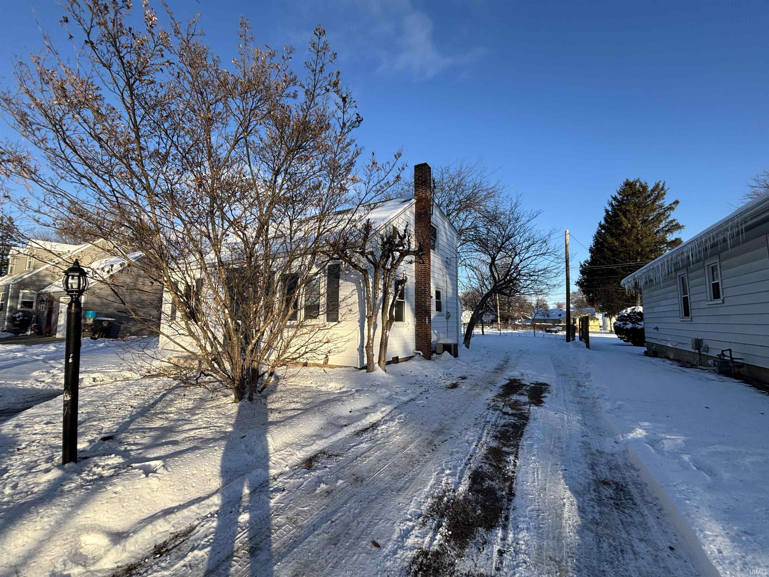 Snow covered property with a chimney