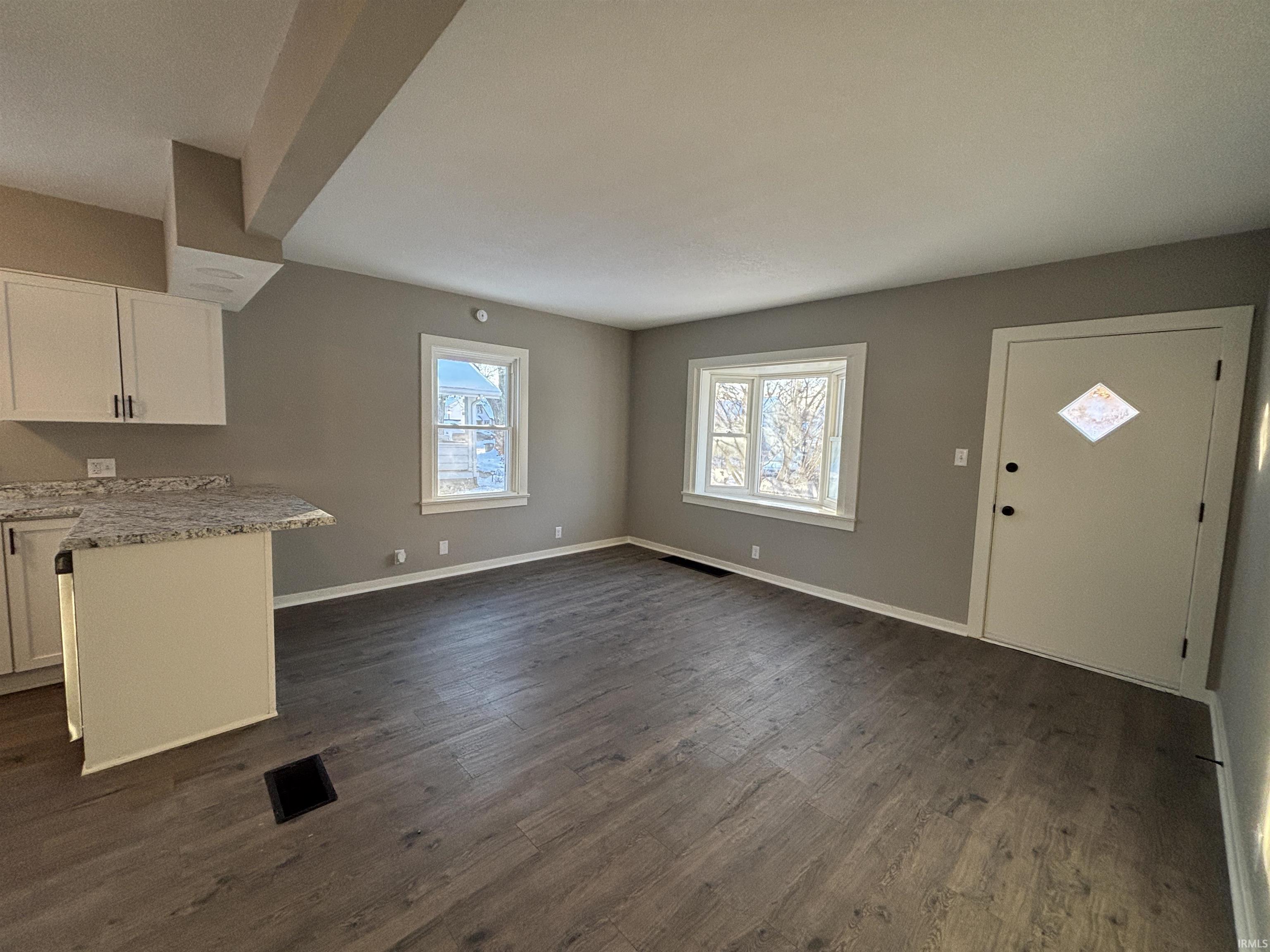 Foyer entrance with baseboards and dark wood-style flooring