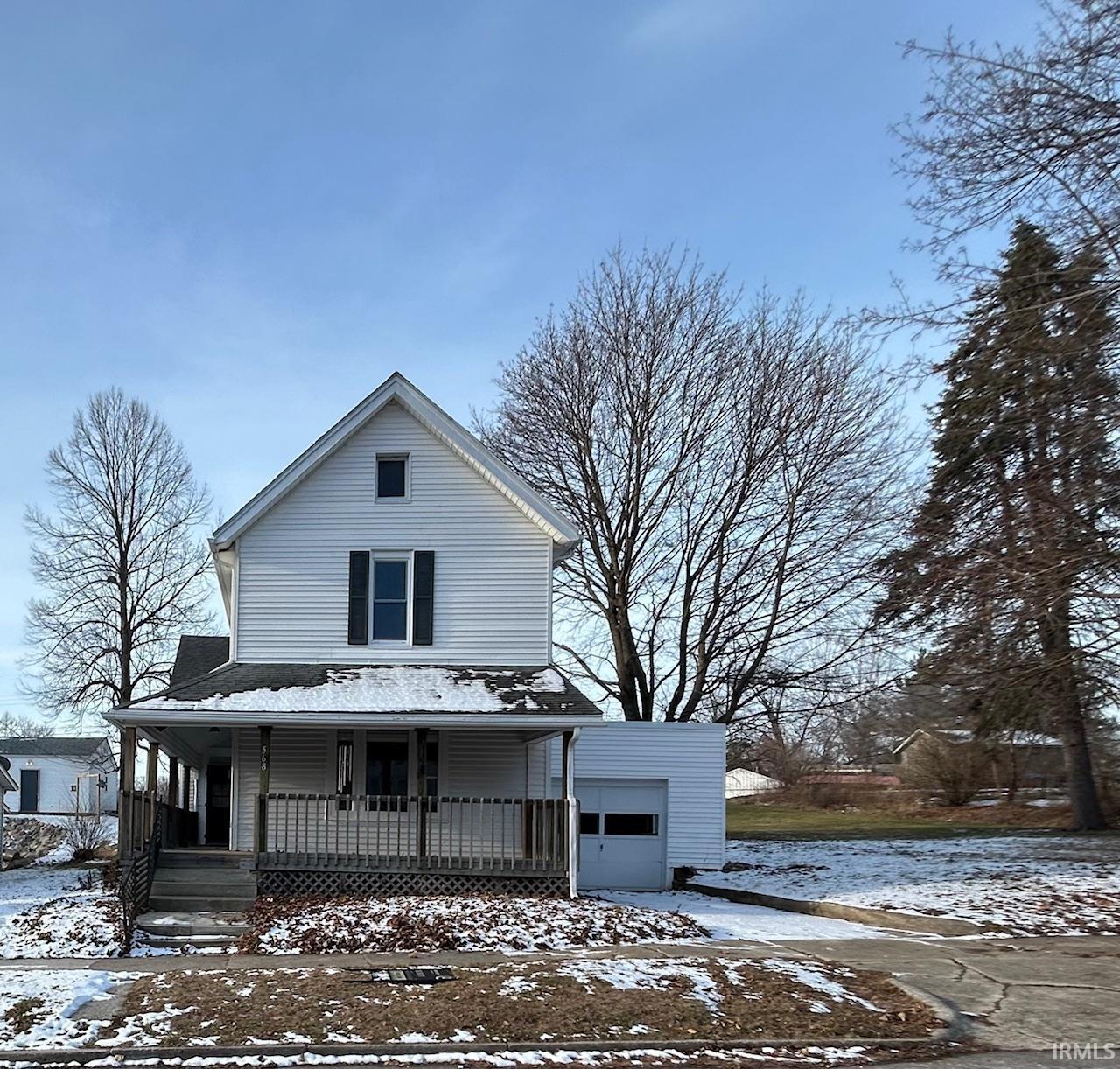 View of front of home with a porch and a garage