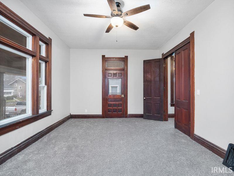 Unfurnished room featuring carpet floors and a ceiling fan