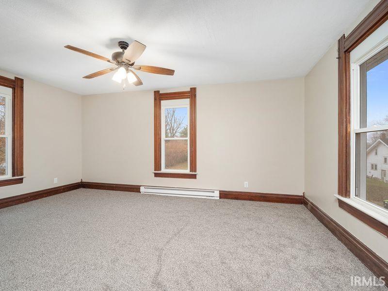 Spare room with light carpet and a baseboard heating unit