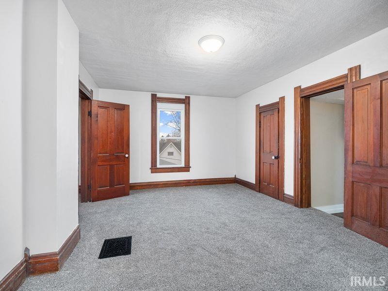 Unfurnished bedroom with a textured ceiling and carpet flooring