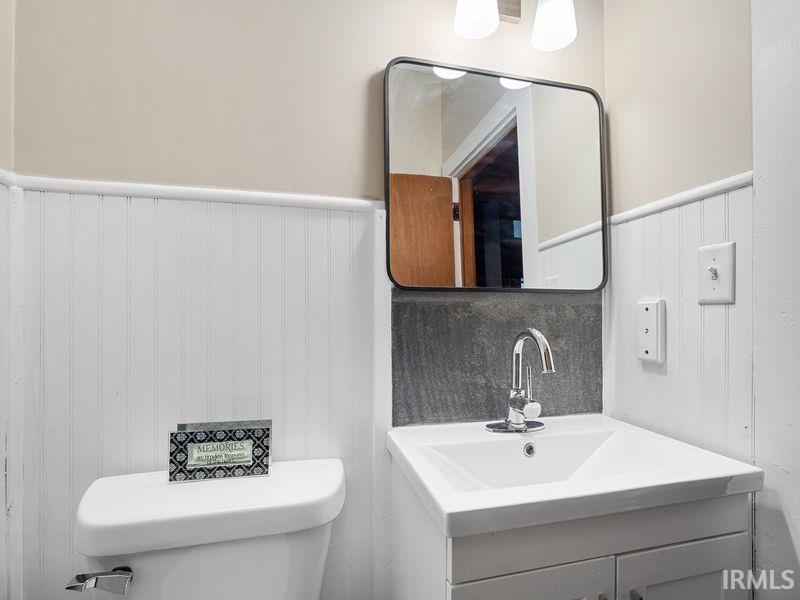 Half bath with wainscoting and vanity