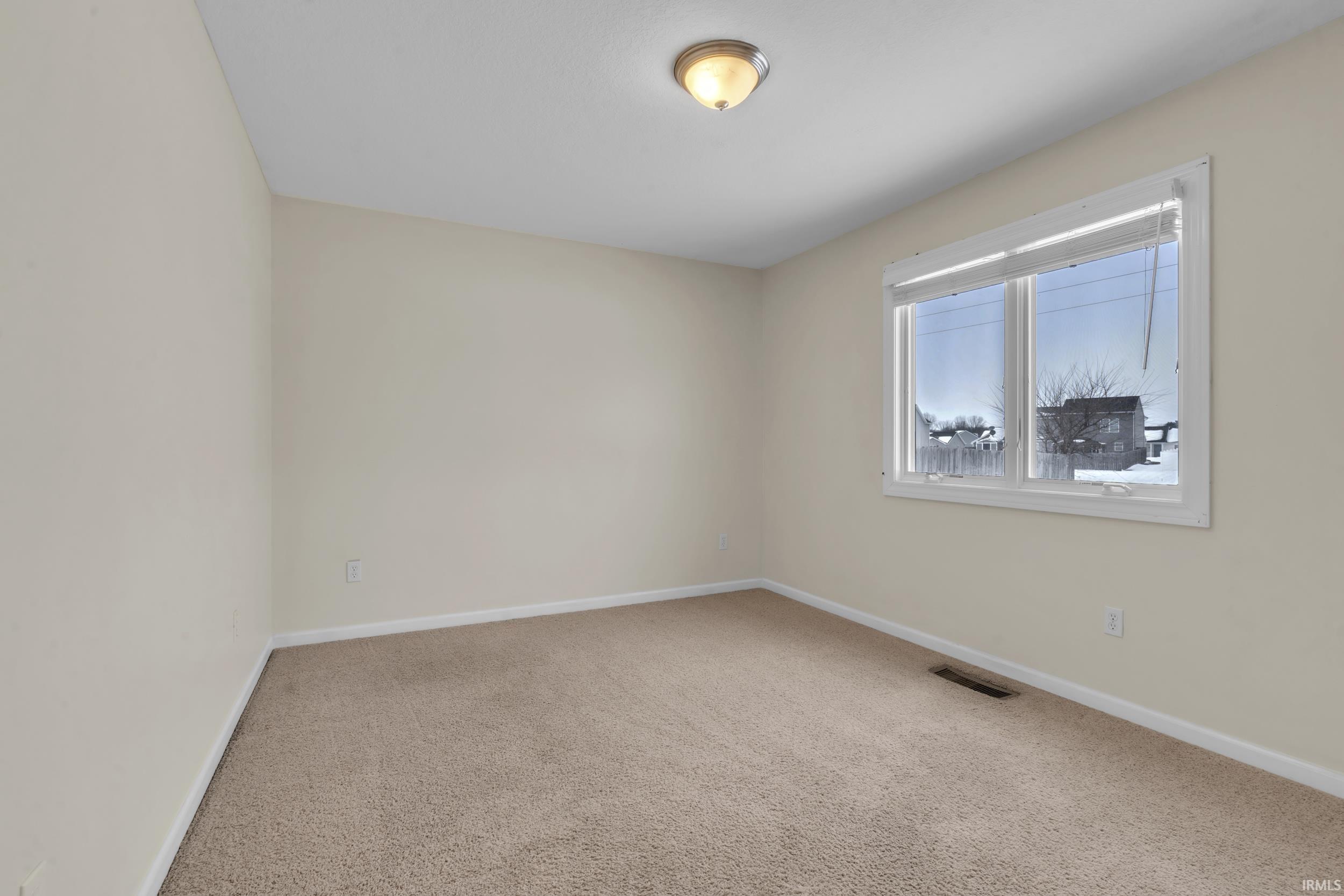 Unfurnished room with light colored carpet and baseboards