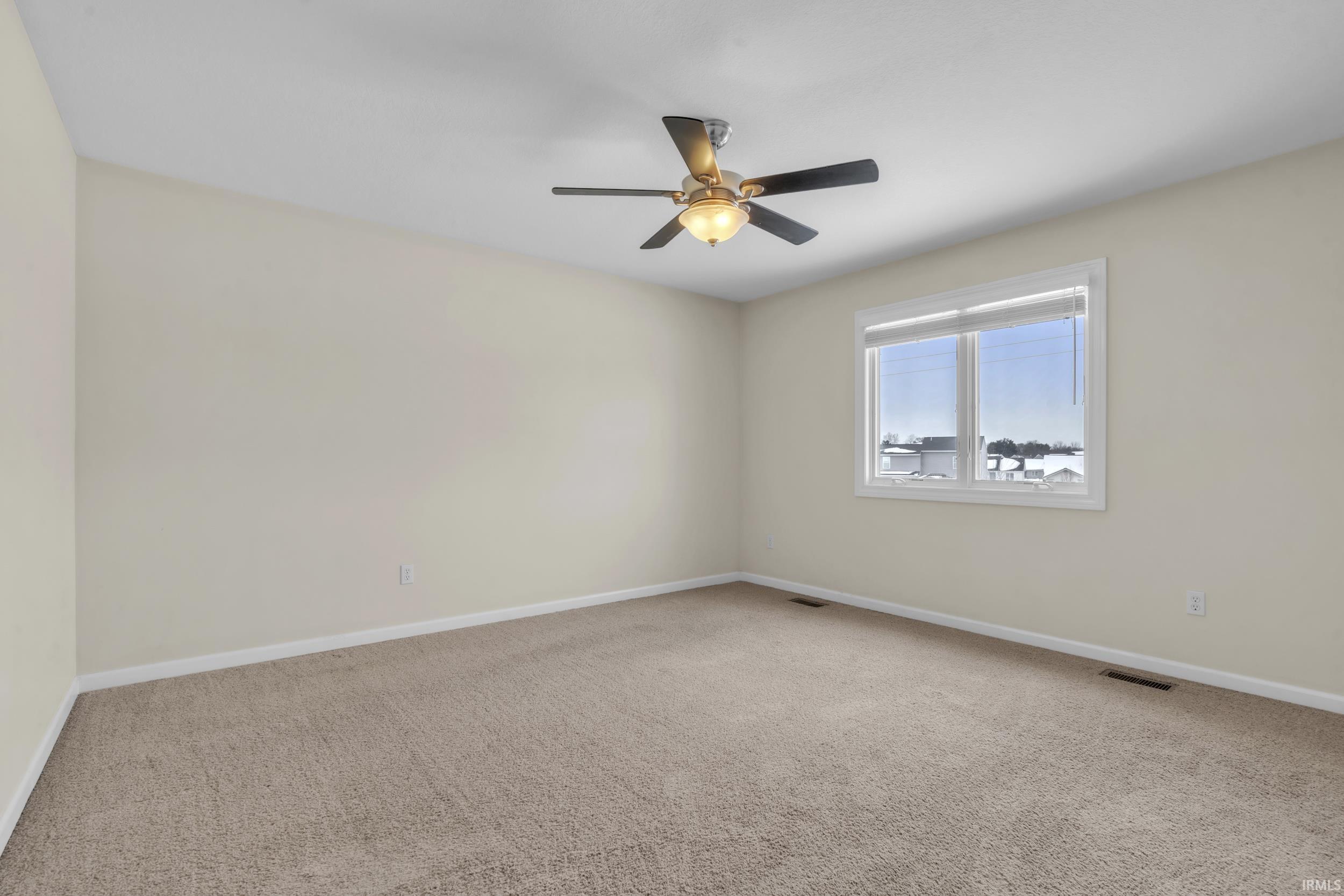 Unfurnished room featuring light colored carpet and ceiling fan