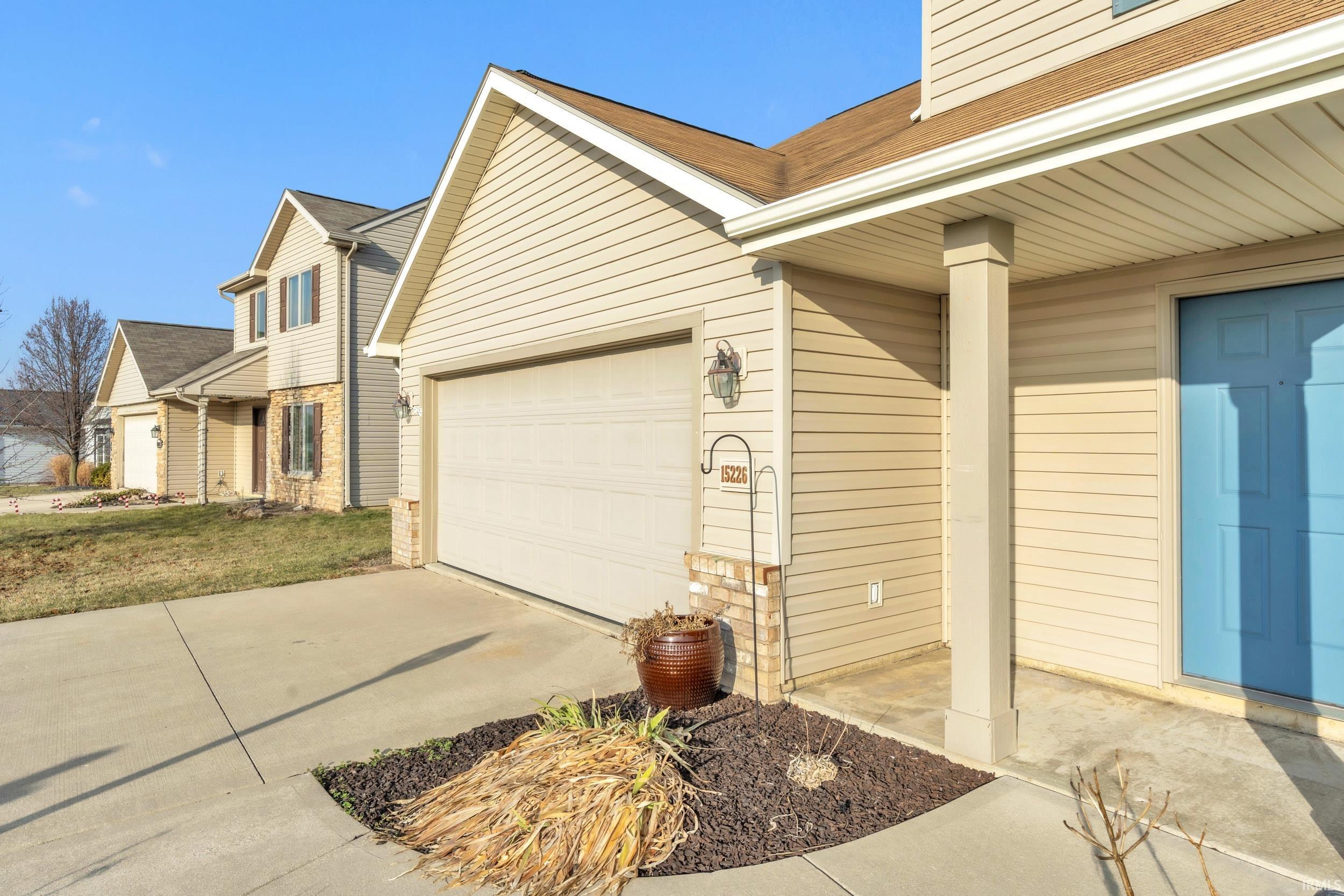 View of home's exterior with concrete driveway, a shingled roof, and a garage
