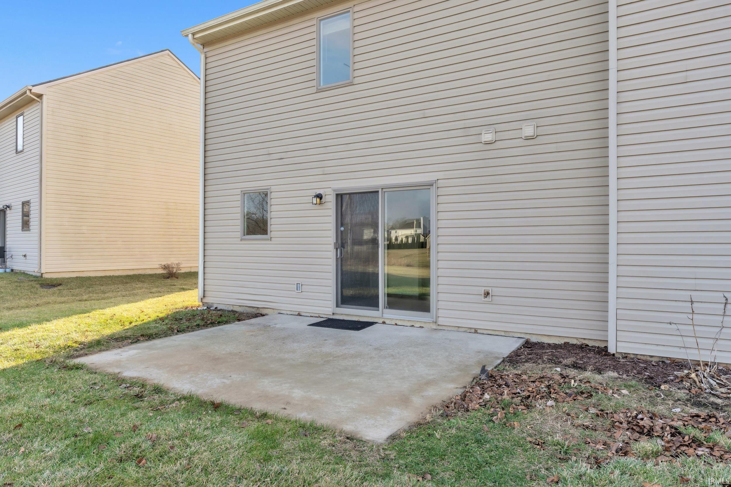 Rear view of property with a patio area and a yard