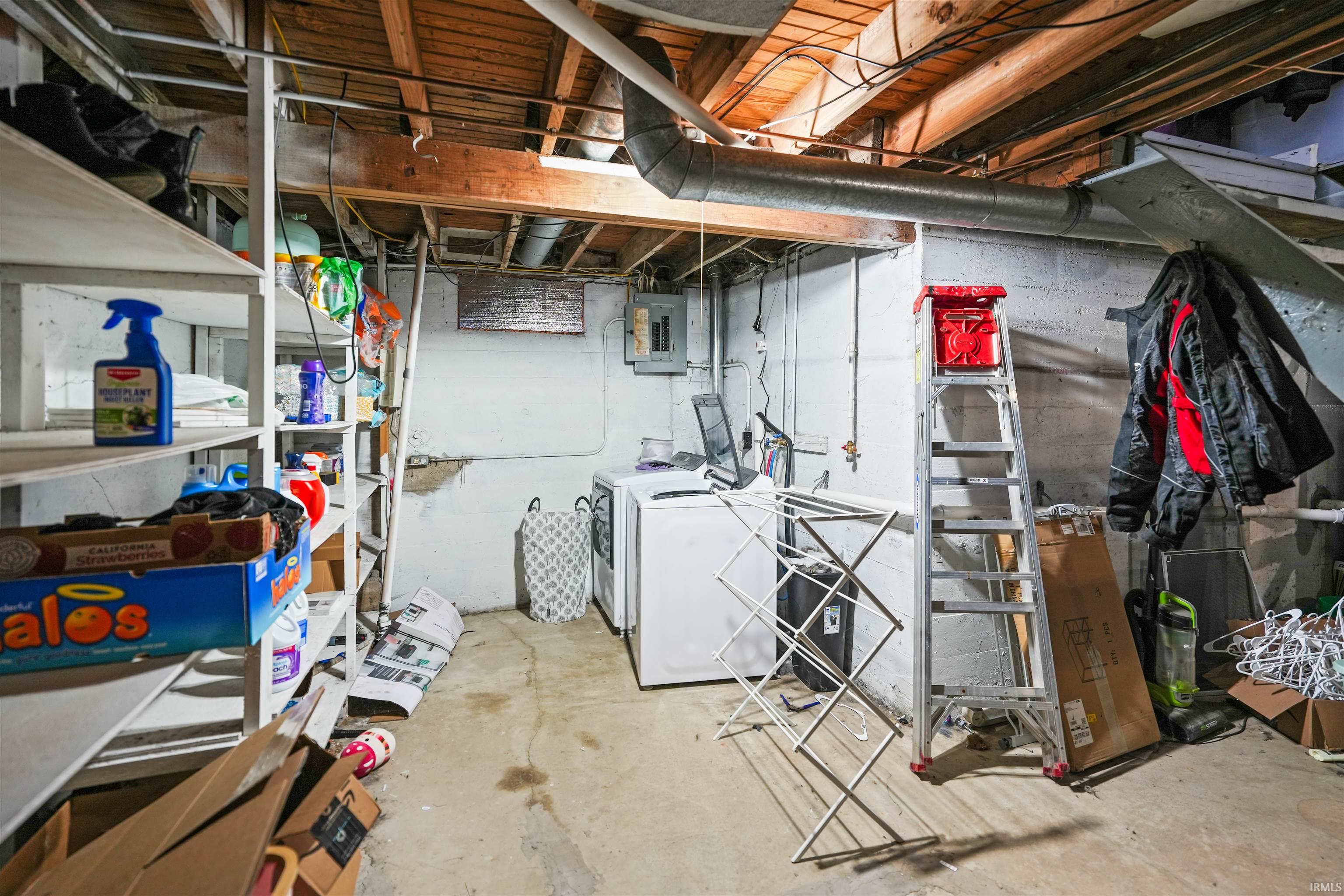 Unfinished below grade area with electric panel and Washer and Dryer hookup.