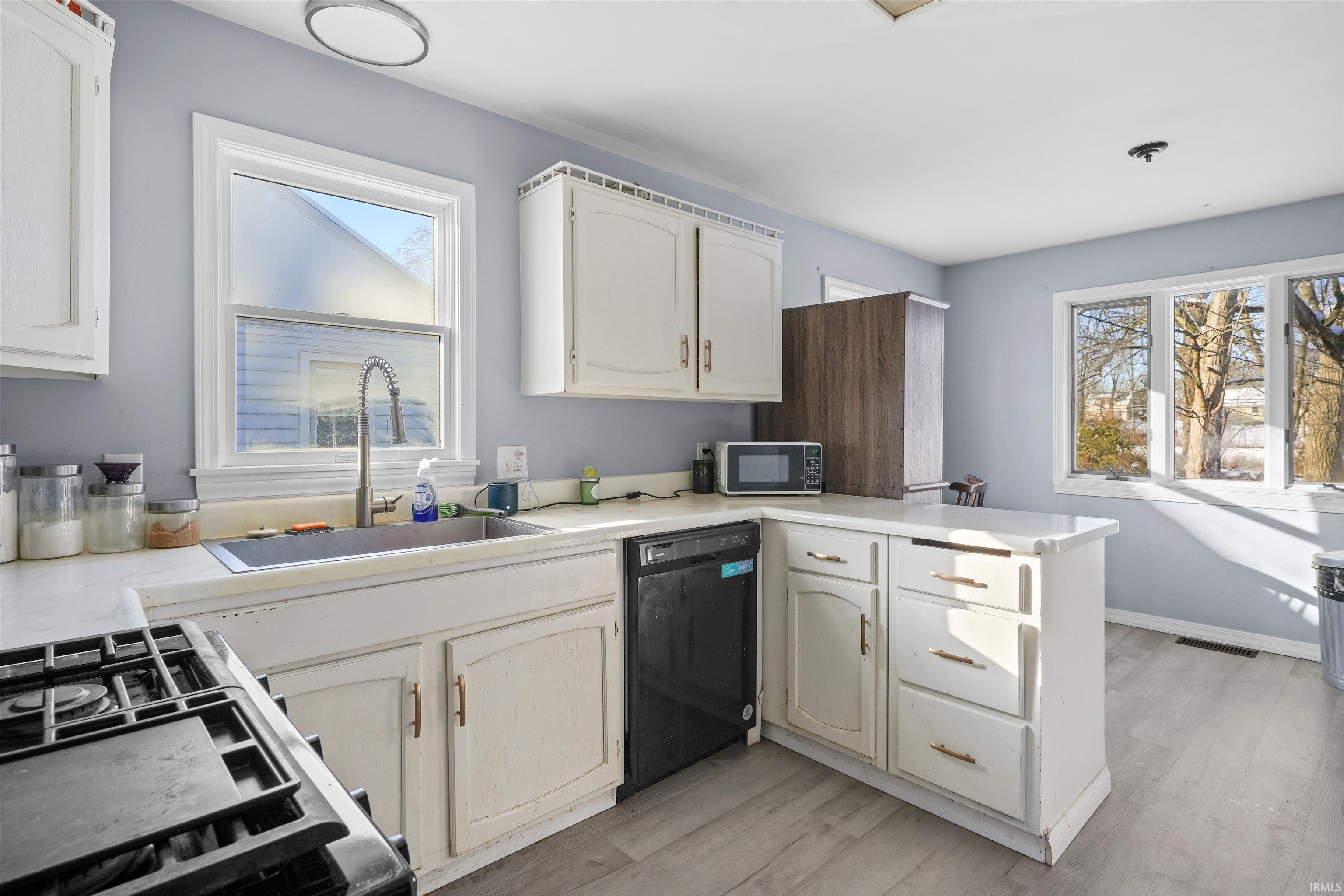 Kitchen with light countertops, a peninsula,  and light flooring