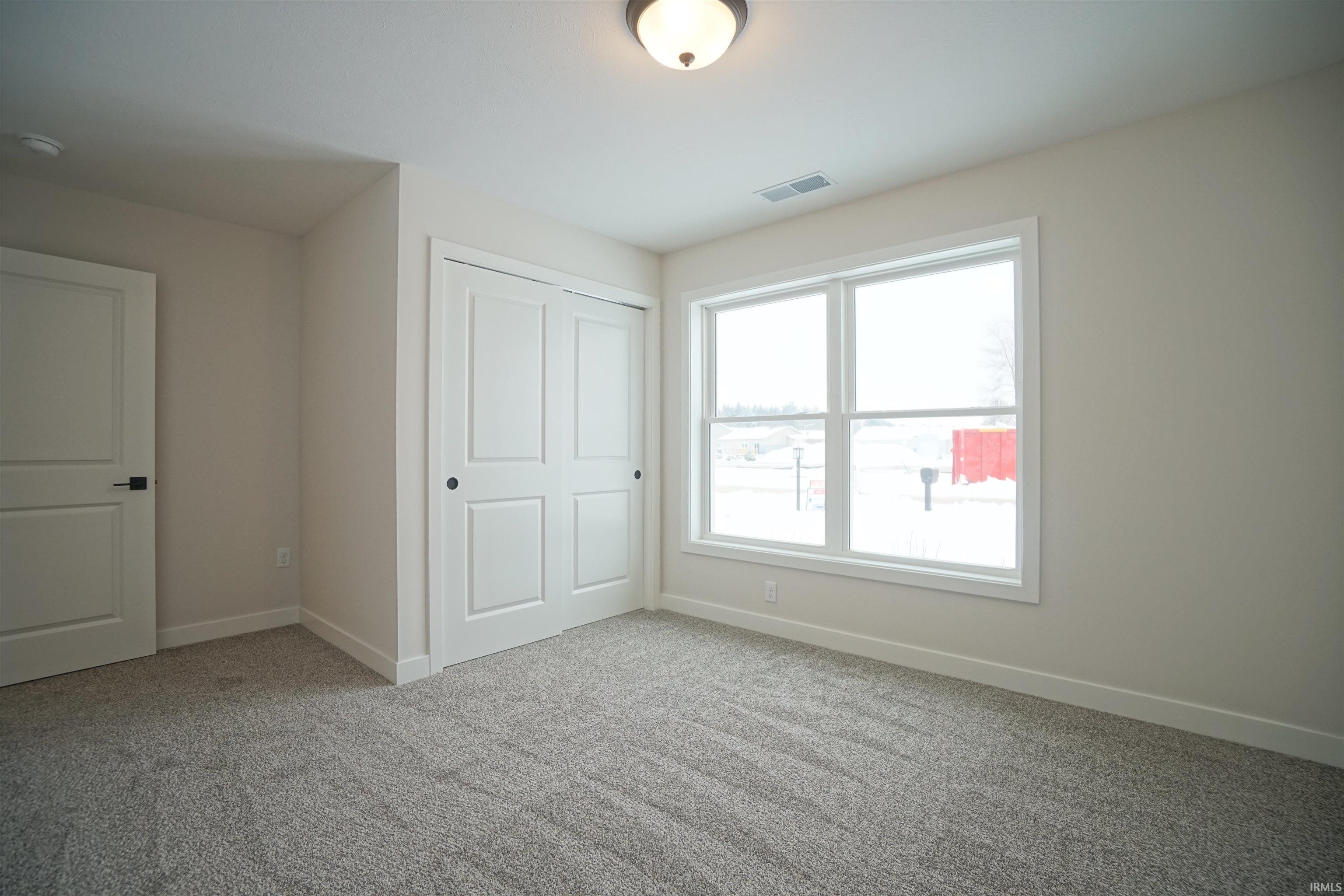 Unfurnished bedroom with a closet and light carpet