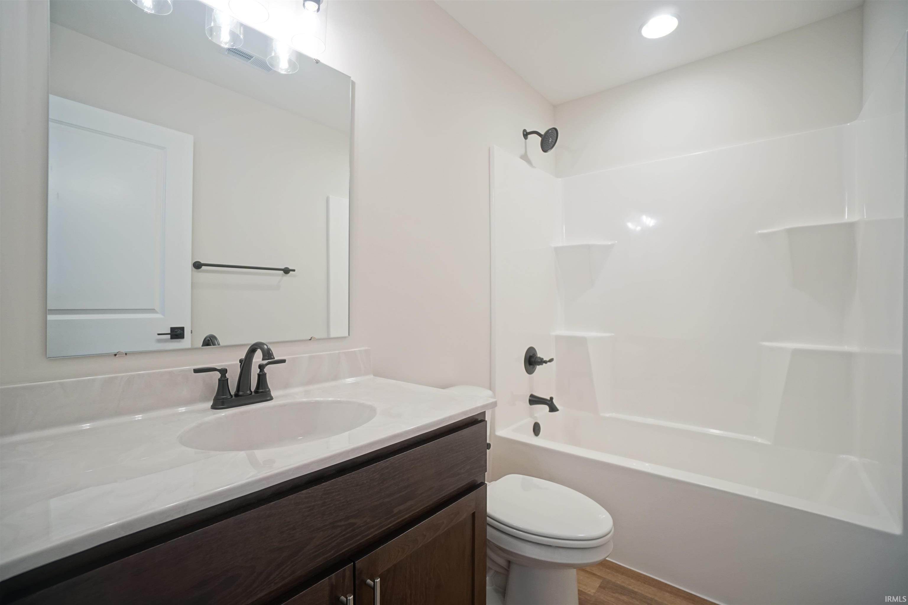 Full bathroom with vanity,  shower combination, and light wood-type flooring