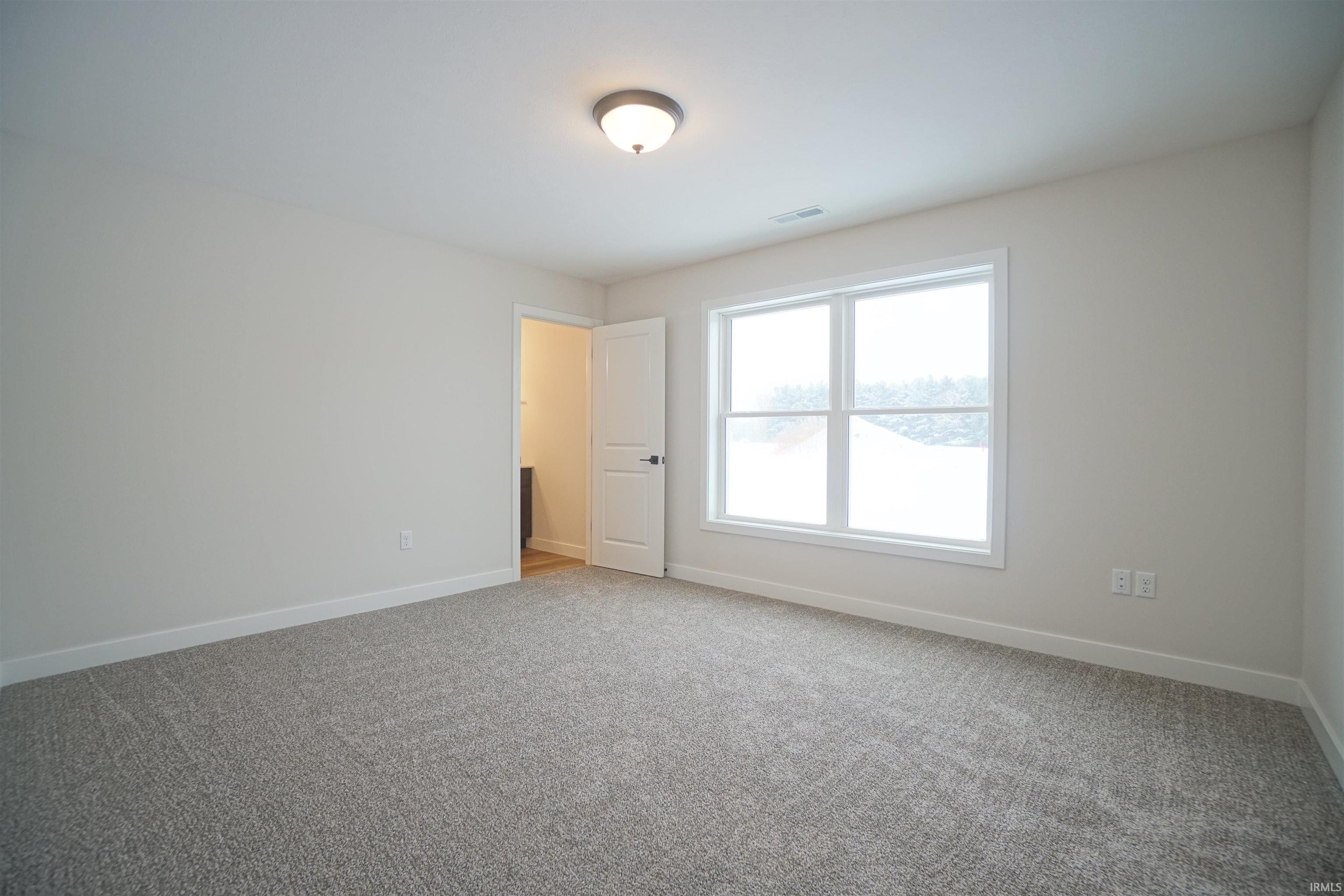 Unfurnished room with baseboards and light carpet