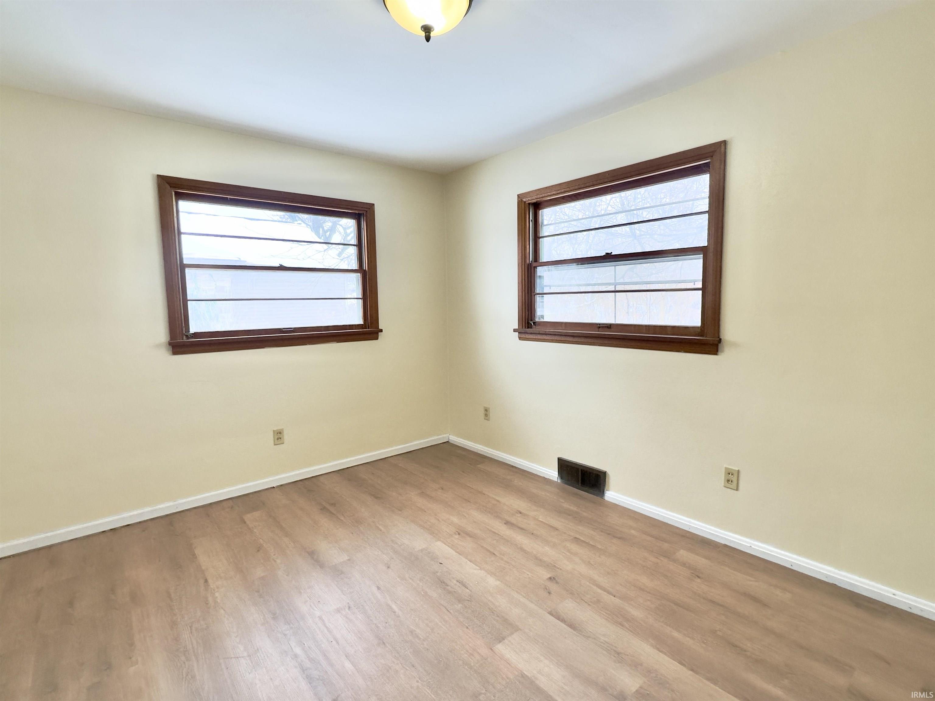 Empty room with baseboards and light wood finished floors