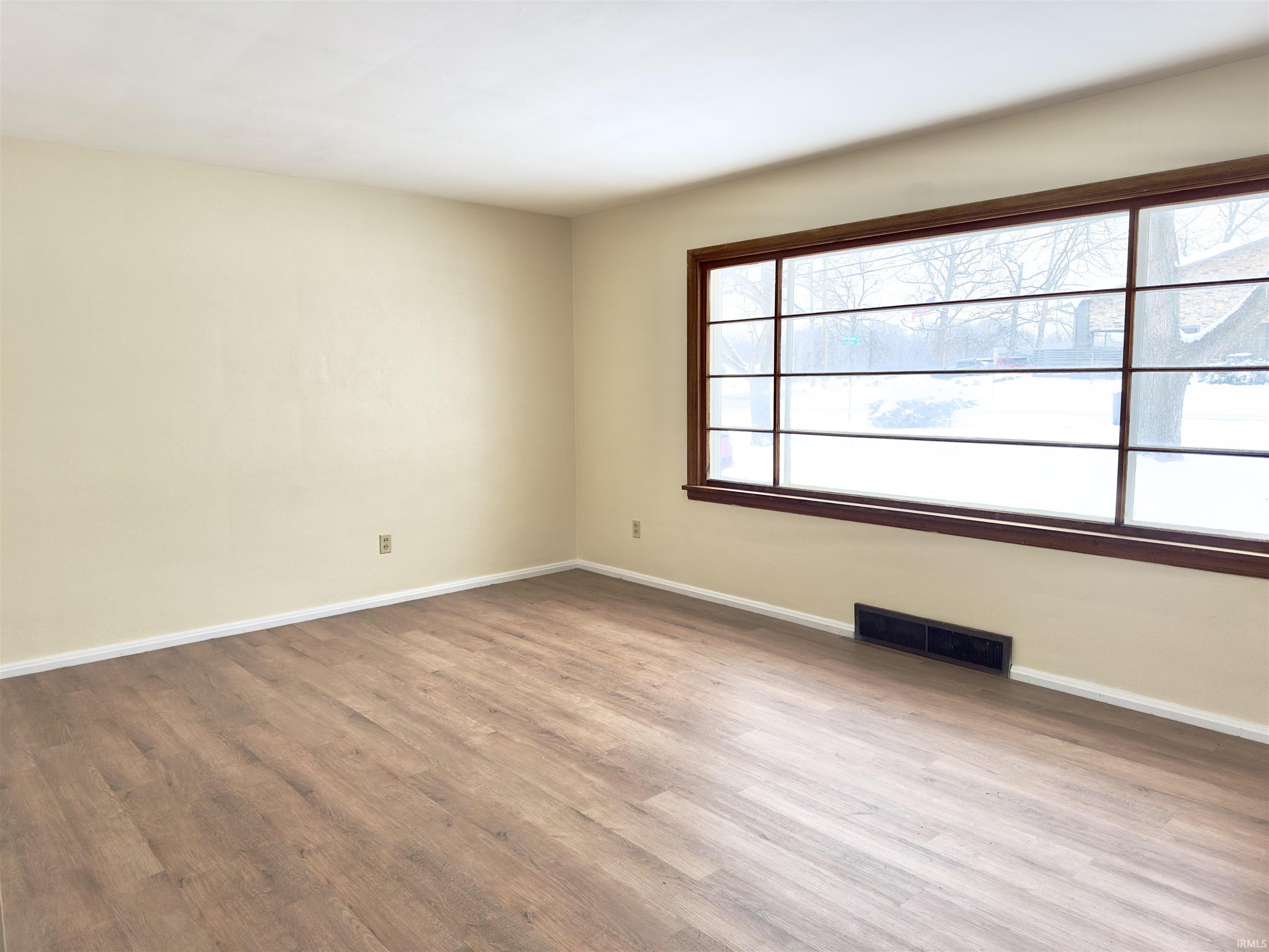 Empty room with baseboards and light wood-style floors