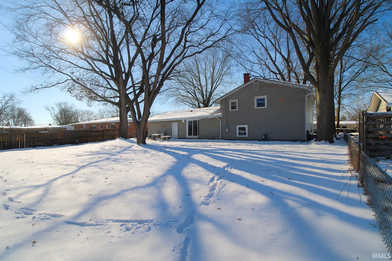 Snow covered property featuring a chimney