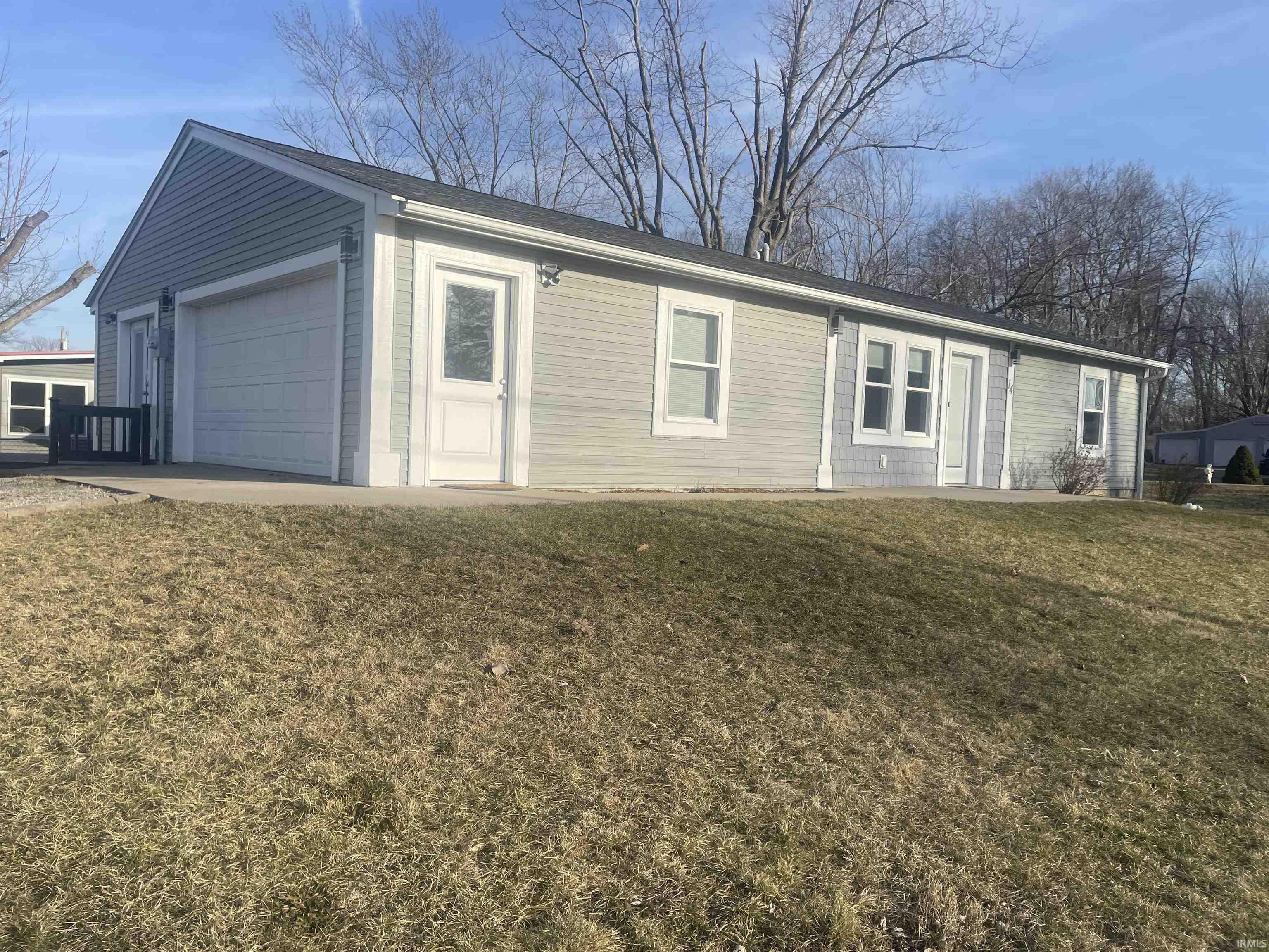 View of front of home featuring a front lawn and a detached garage