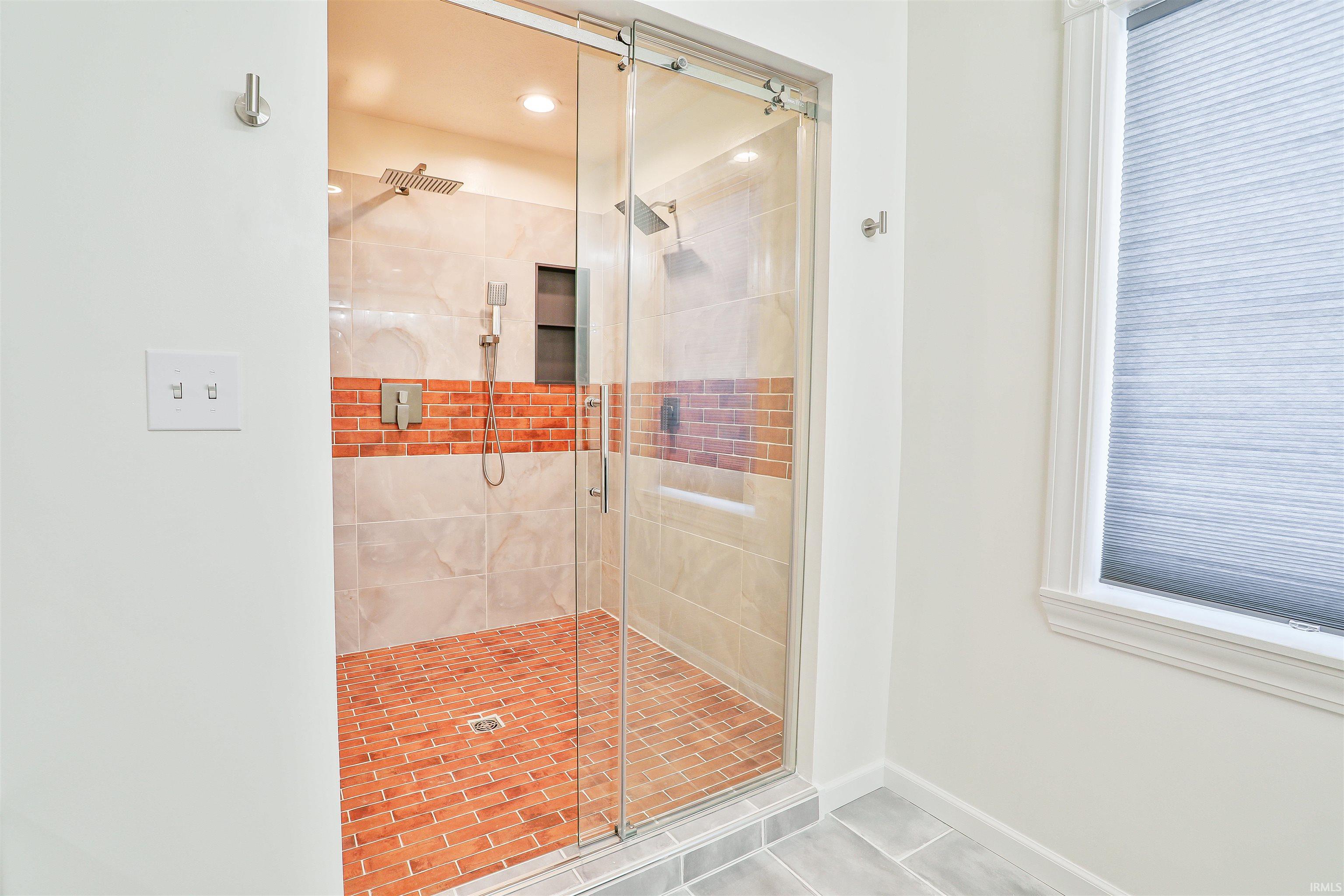 Full bath featuring a stall shower and tile patterned flooring