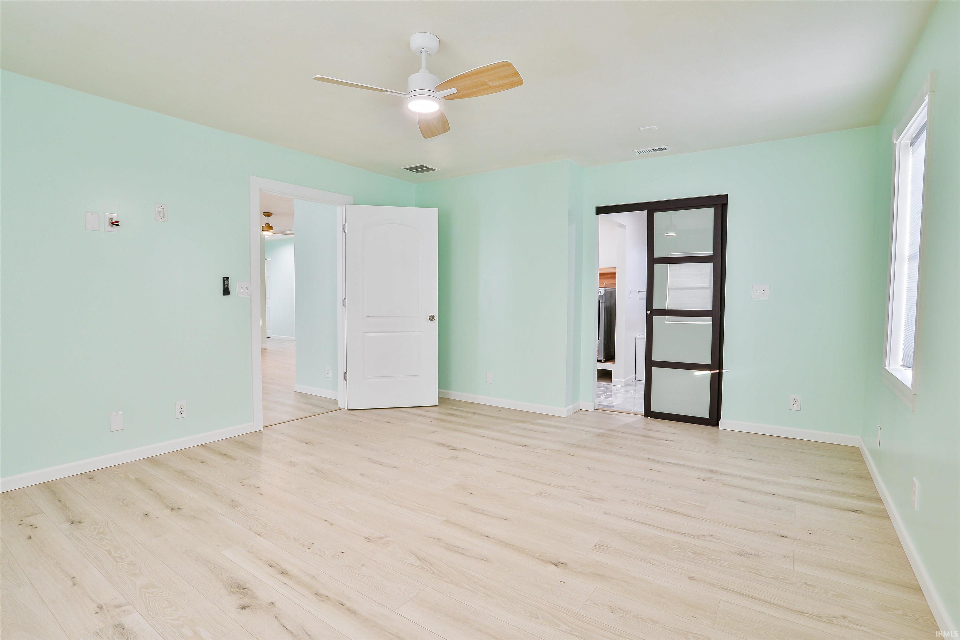 Unfurnished bedroom with light wood finished floors and ceiling fan