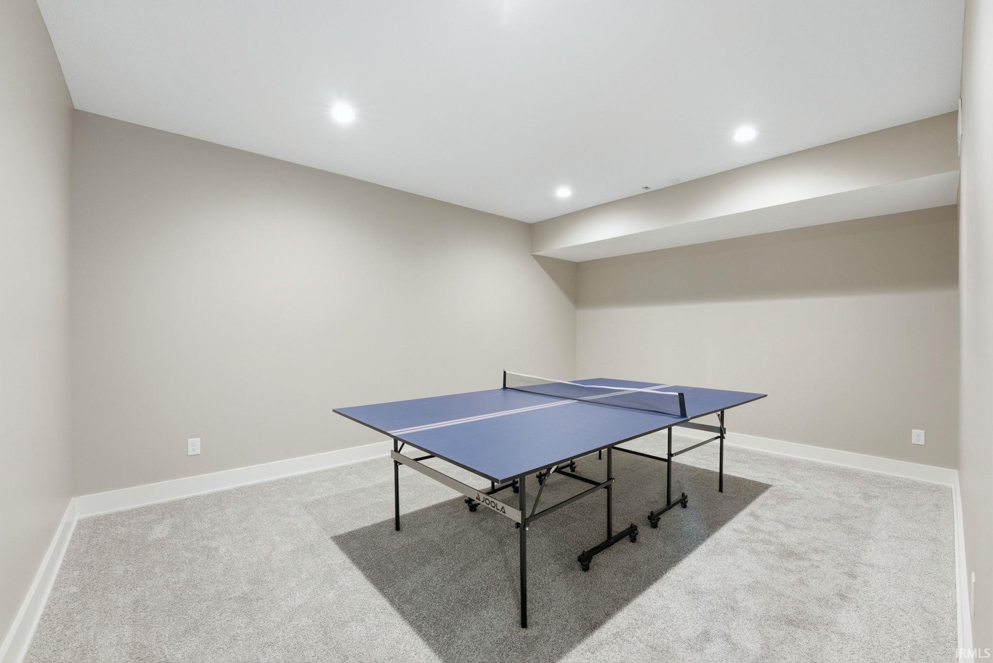 Spacious room featuring light gray carpet, recessed lighting, and neutral wall paint