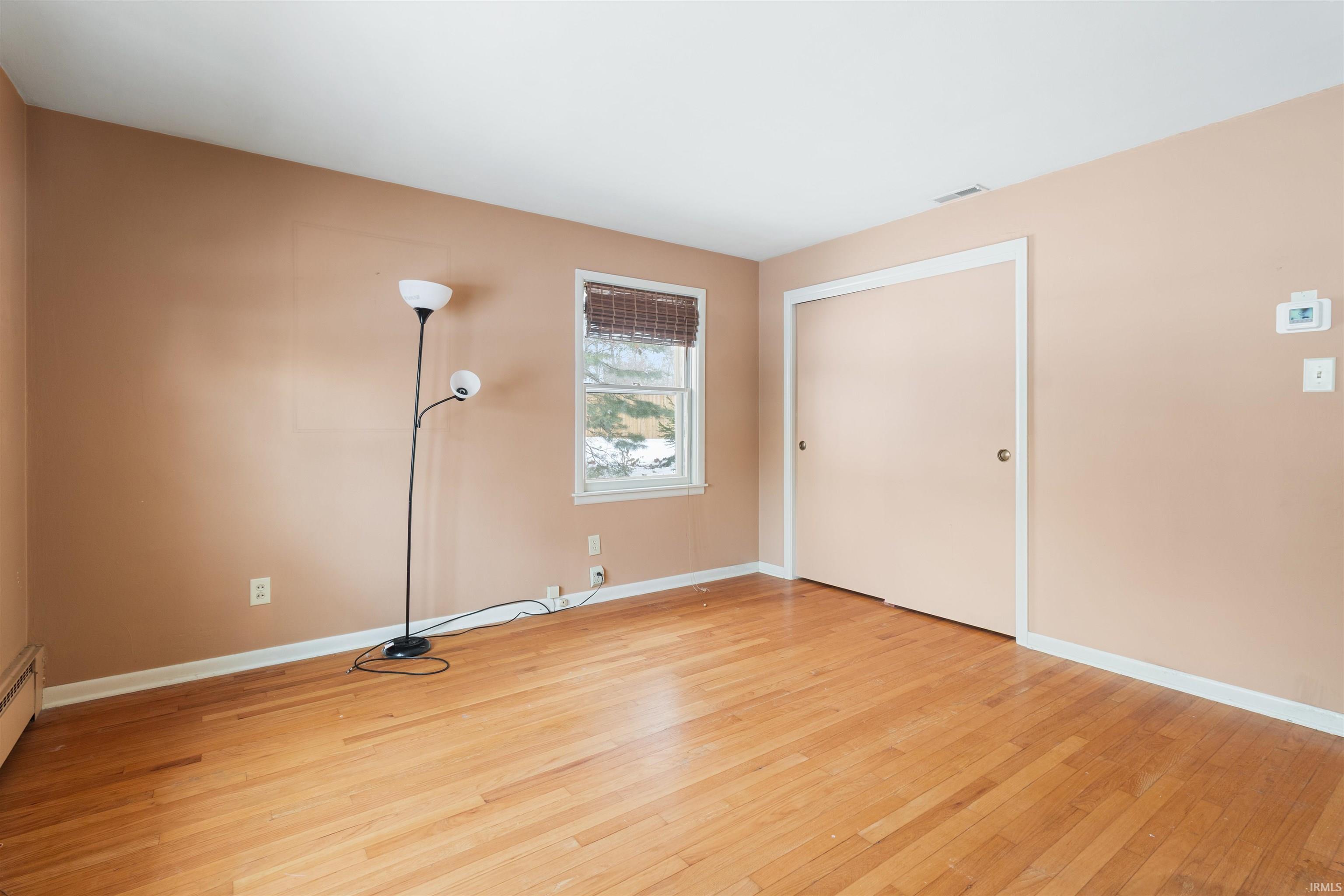 Empty room with light wood-type flooring and baseboards