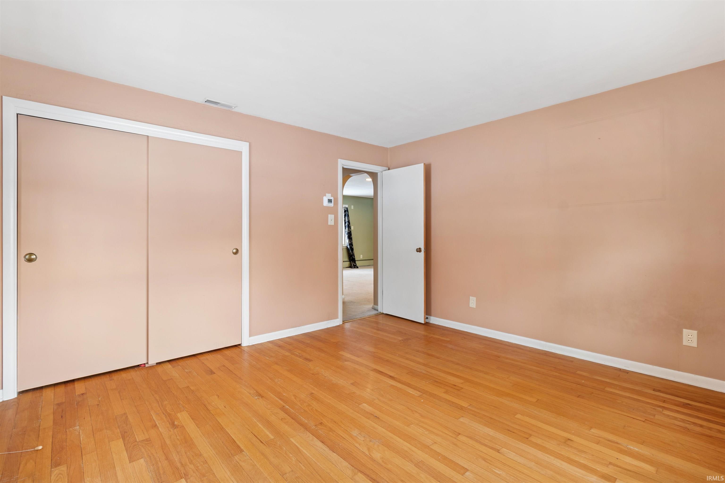 Unfurnished bedroom with light wood-style floors and a closet