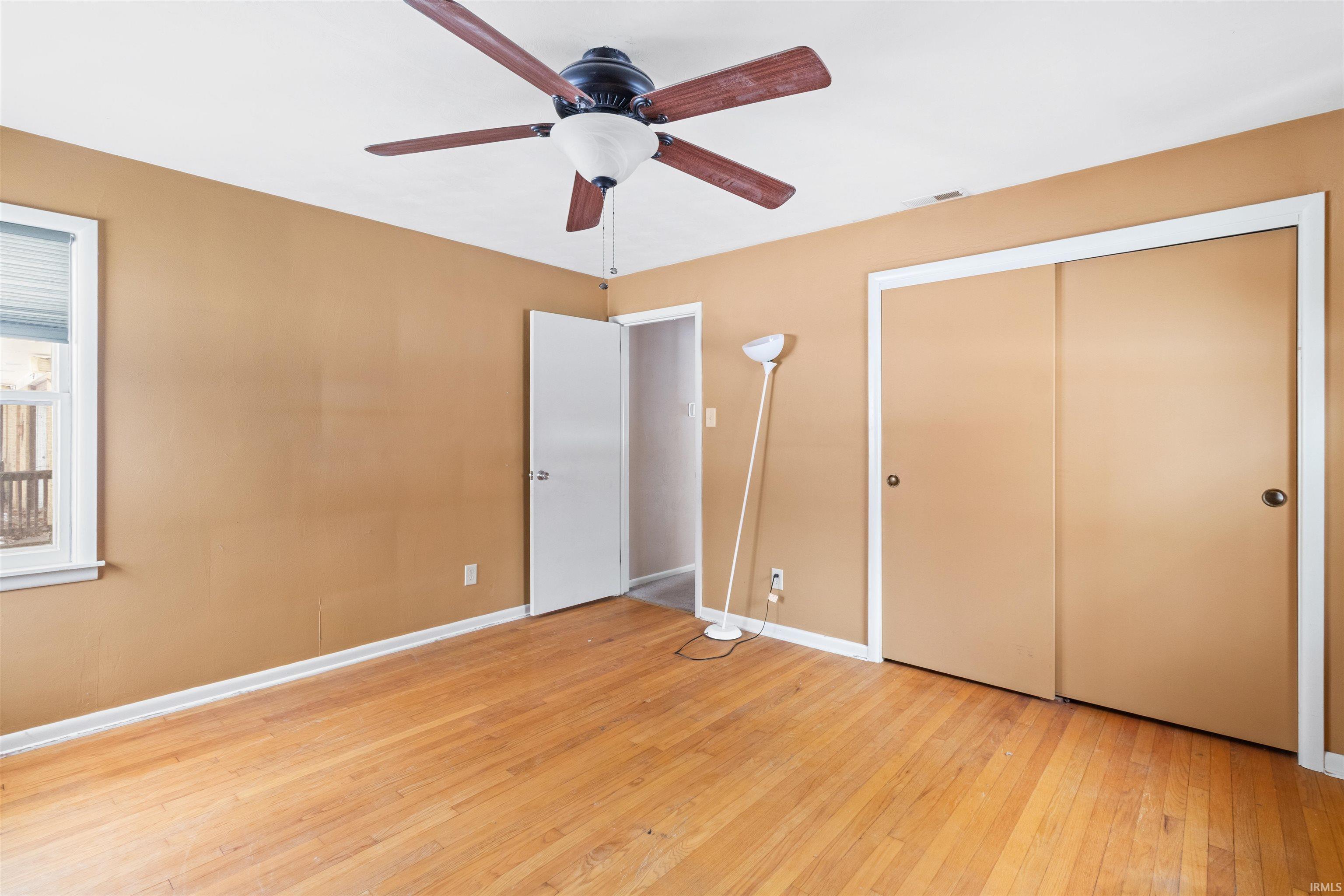 Unfurnished bedroom featuring light wood-type flooring, ceiling fan, and a closet