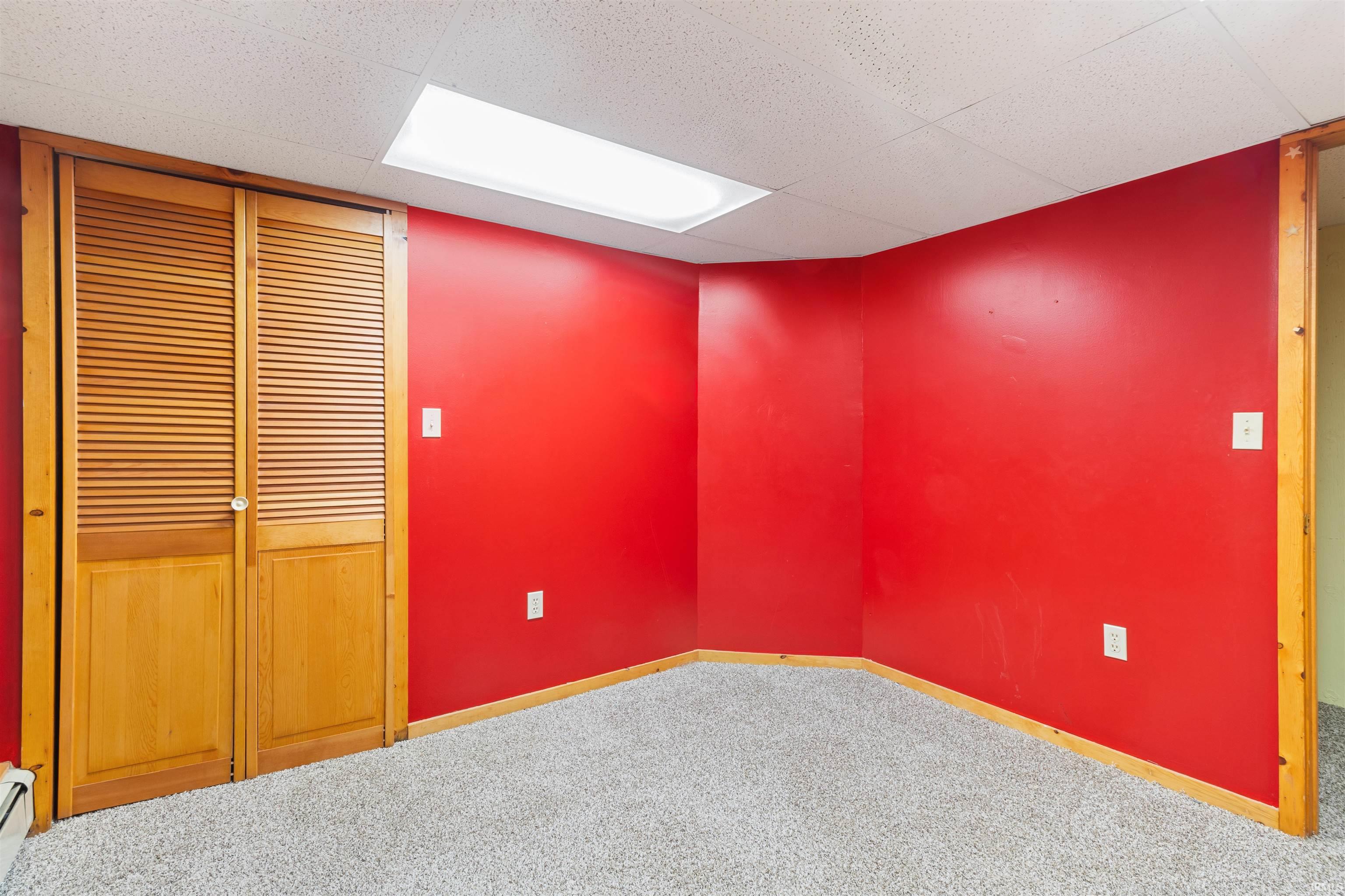 Unfurnished room with carpet, baseboard heating, and a drop ceiling