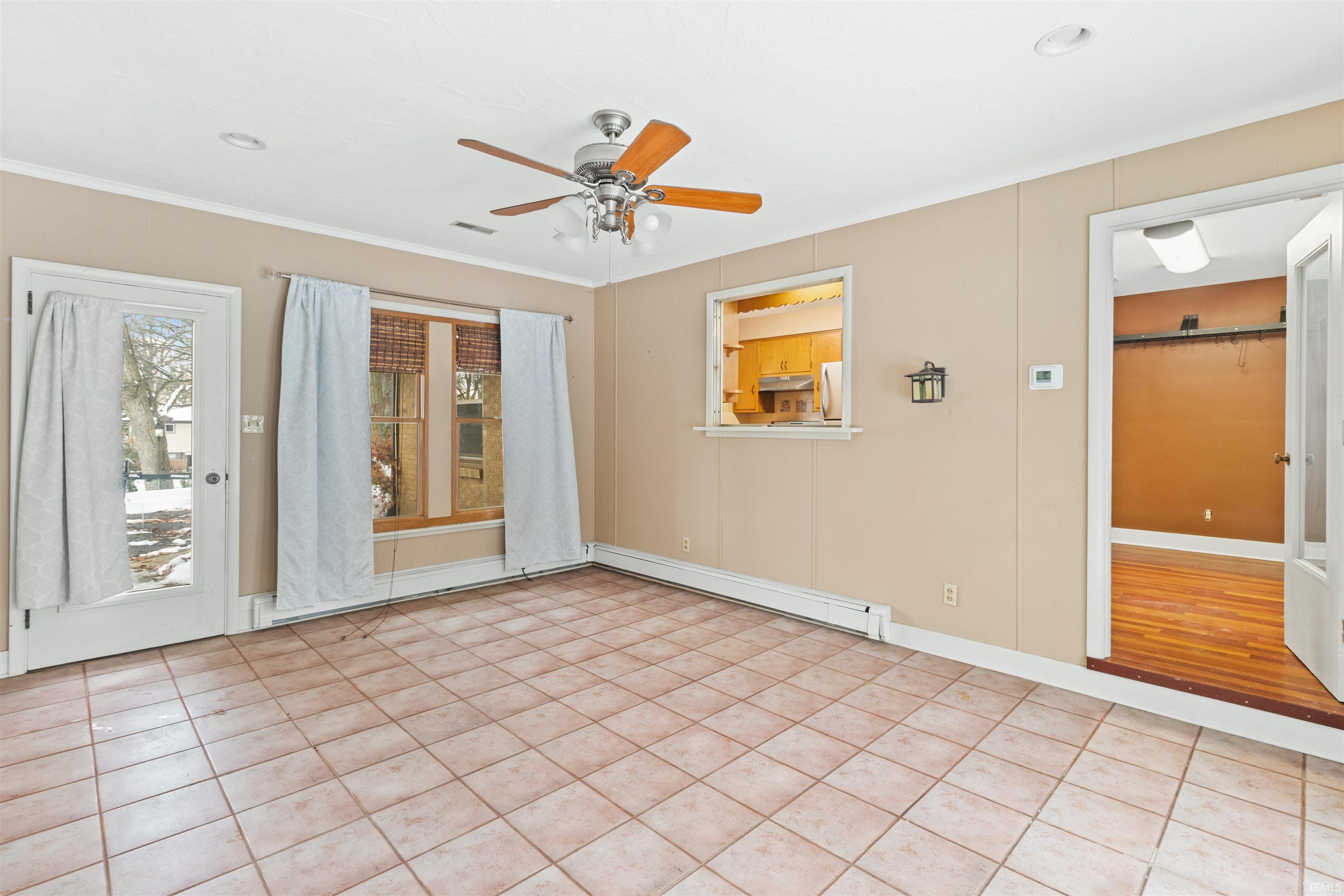 Unfurnished room with a ceiling fan, a baseboard heating unit, light tile patterned flooring, recessed lighting, and ornamental molding