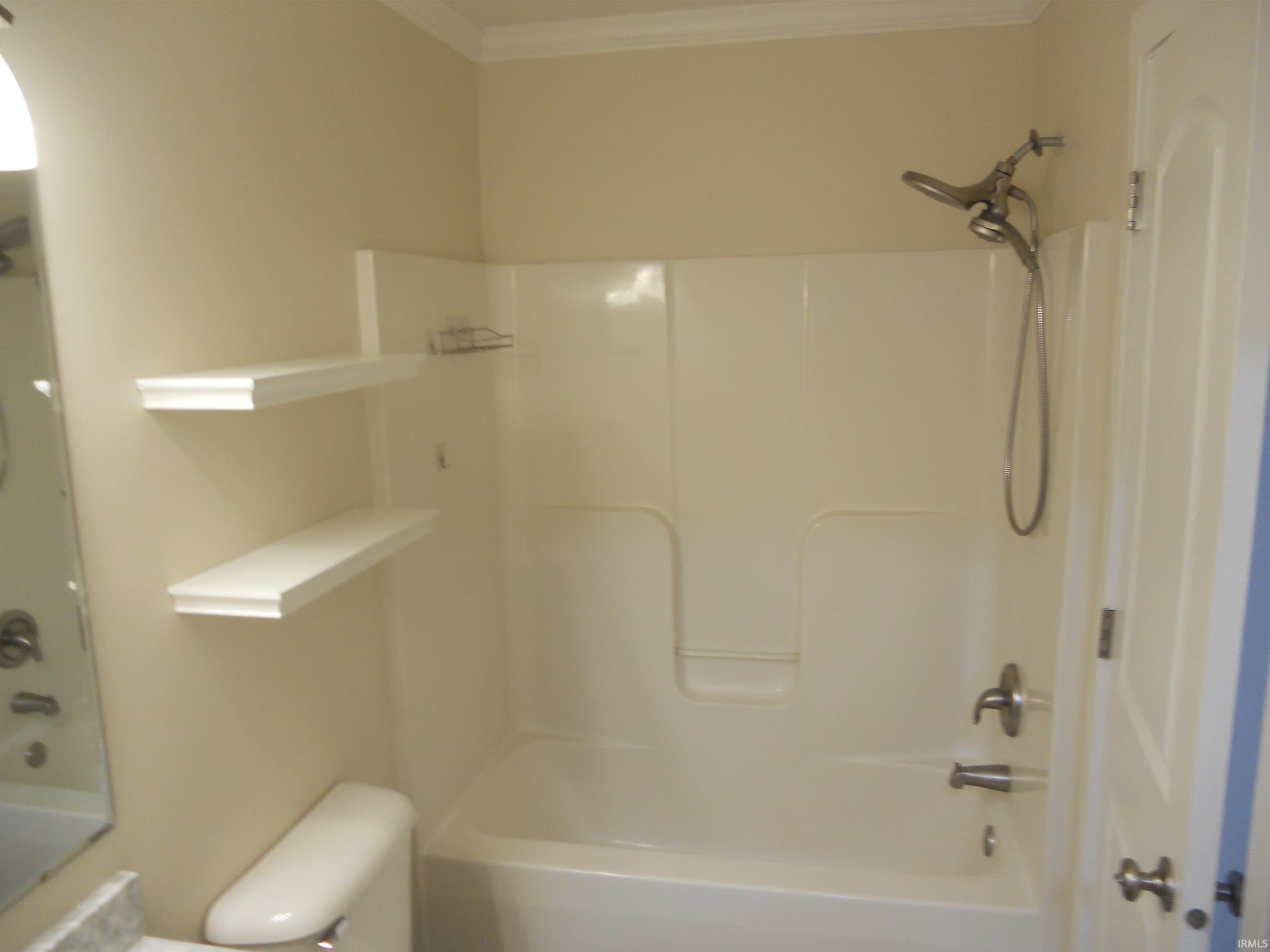 Bathroom featuring shower / tub combination and ornamental molding
