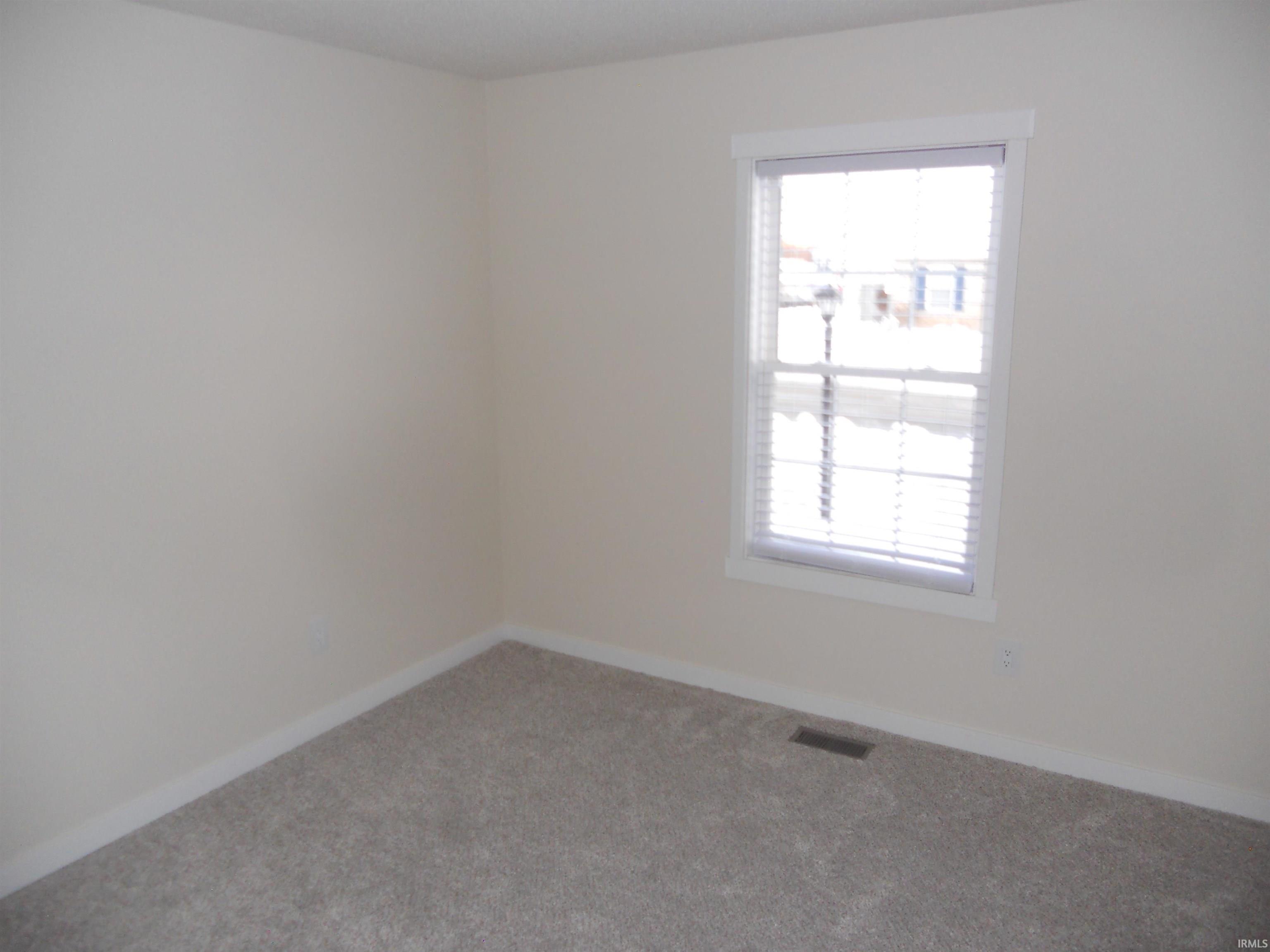 Carpeted empty room with baseboards