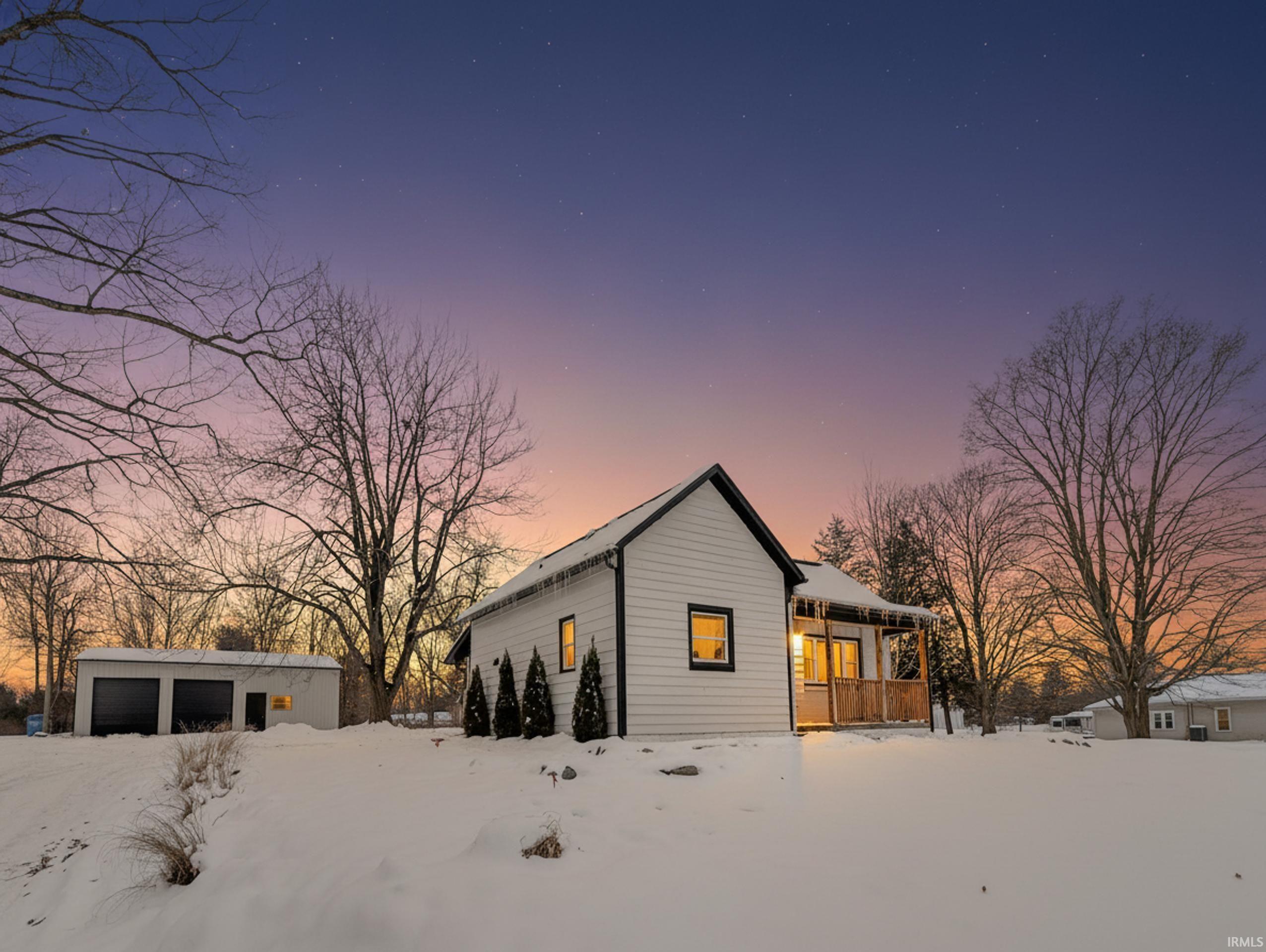 View of front of home with an outdoor structure and a detached garage