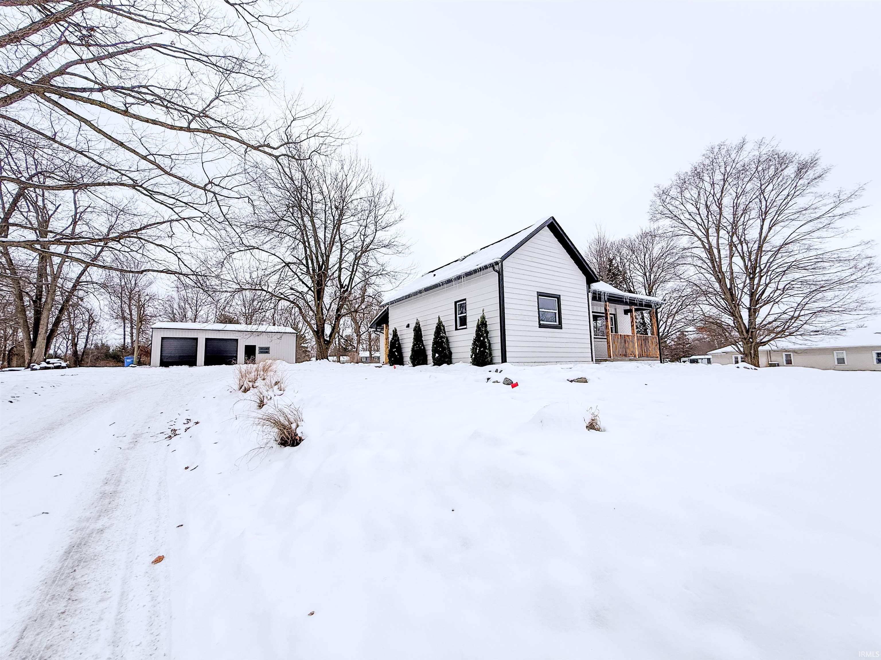 View of snow covered exterior with an outbuilding