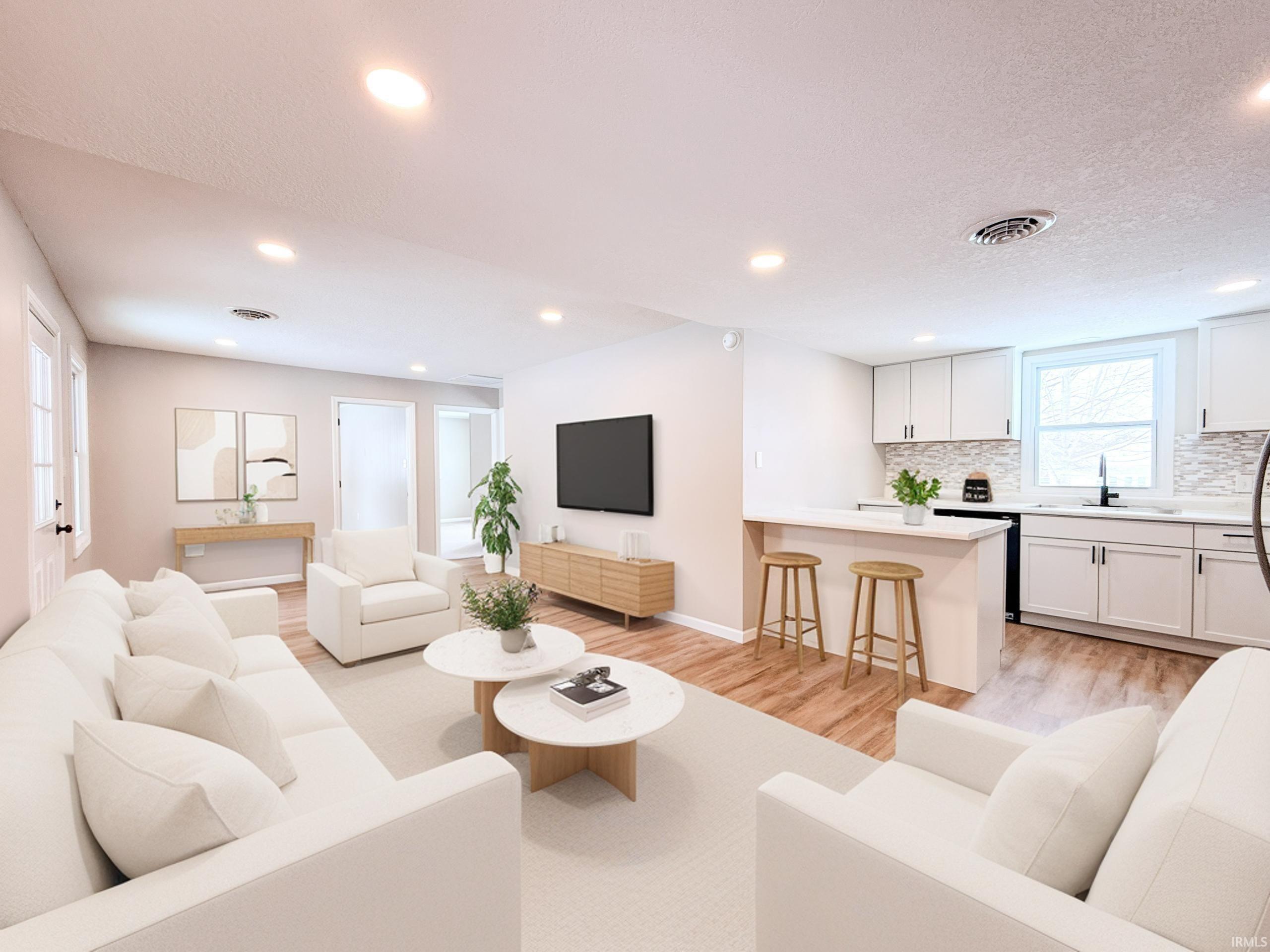 Living area with light wood-style flooring, recessed lighting, and a textured ceiling