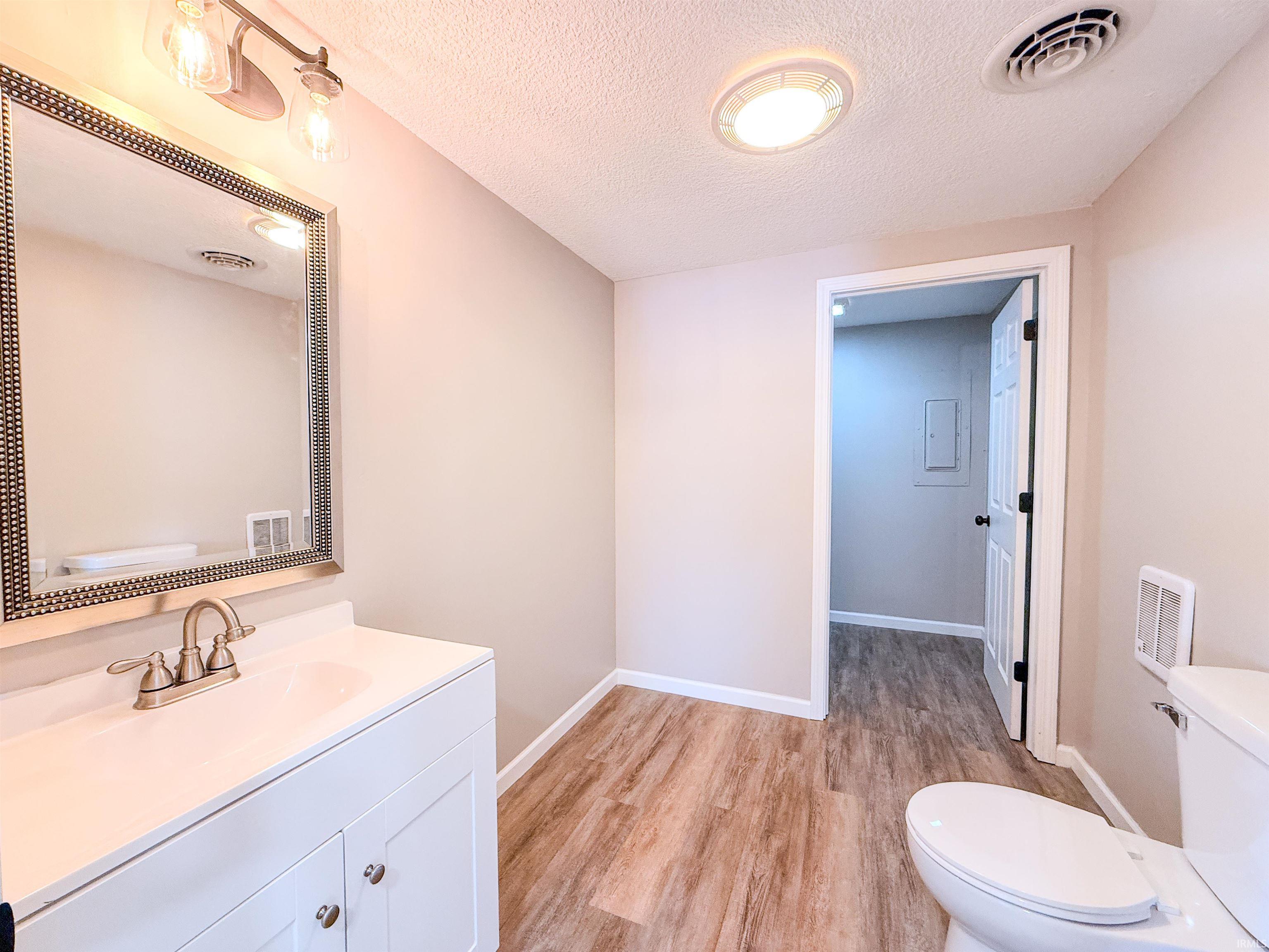 Bathroom featuring vanity, a textured ceiling, and light wood-type flooring