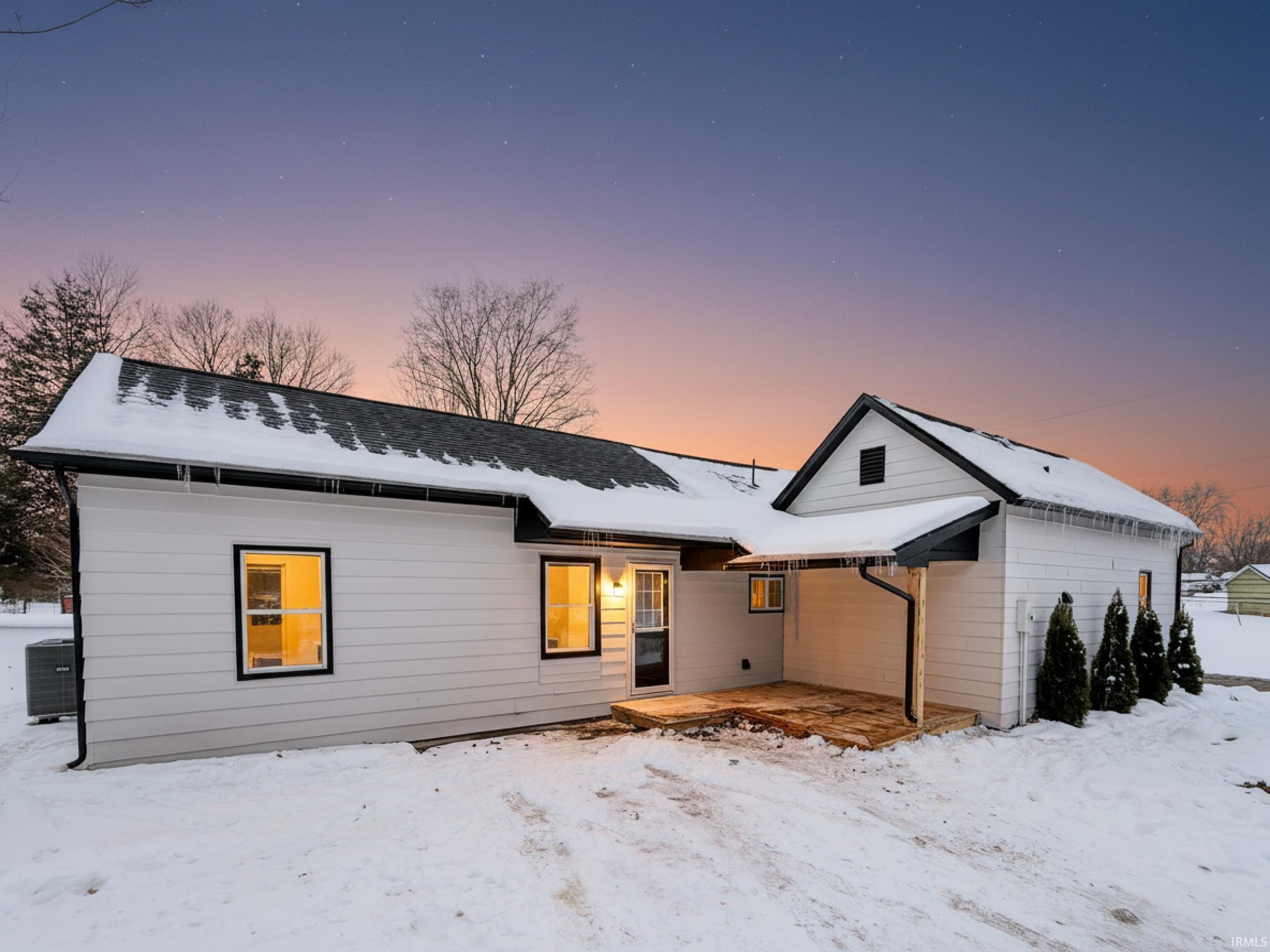 Snow covered property with a patio area
