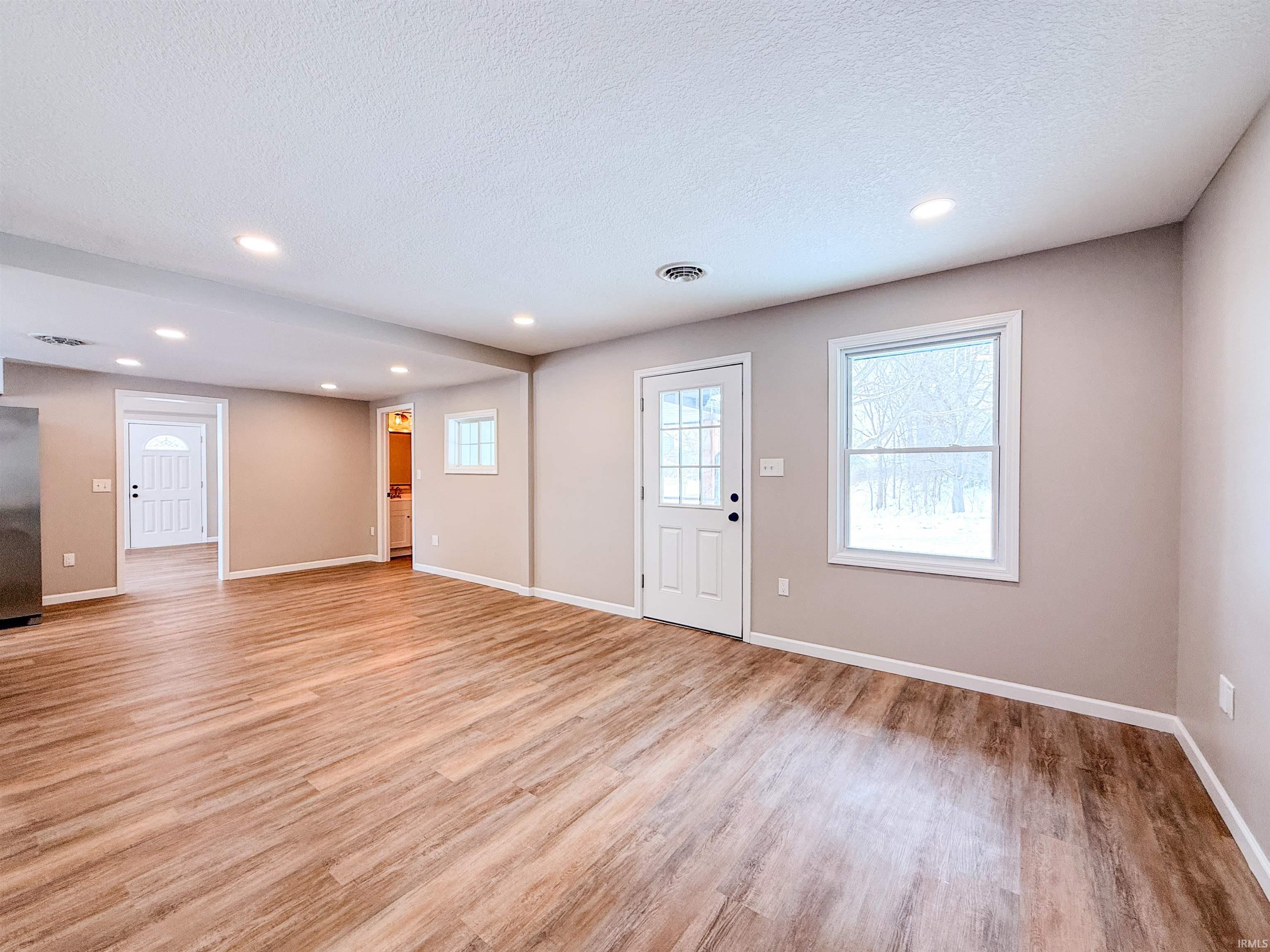 Entryway with recessed lighting, light wood-style floors, and a textured ceiling