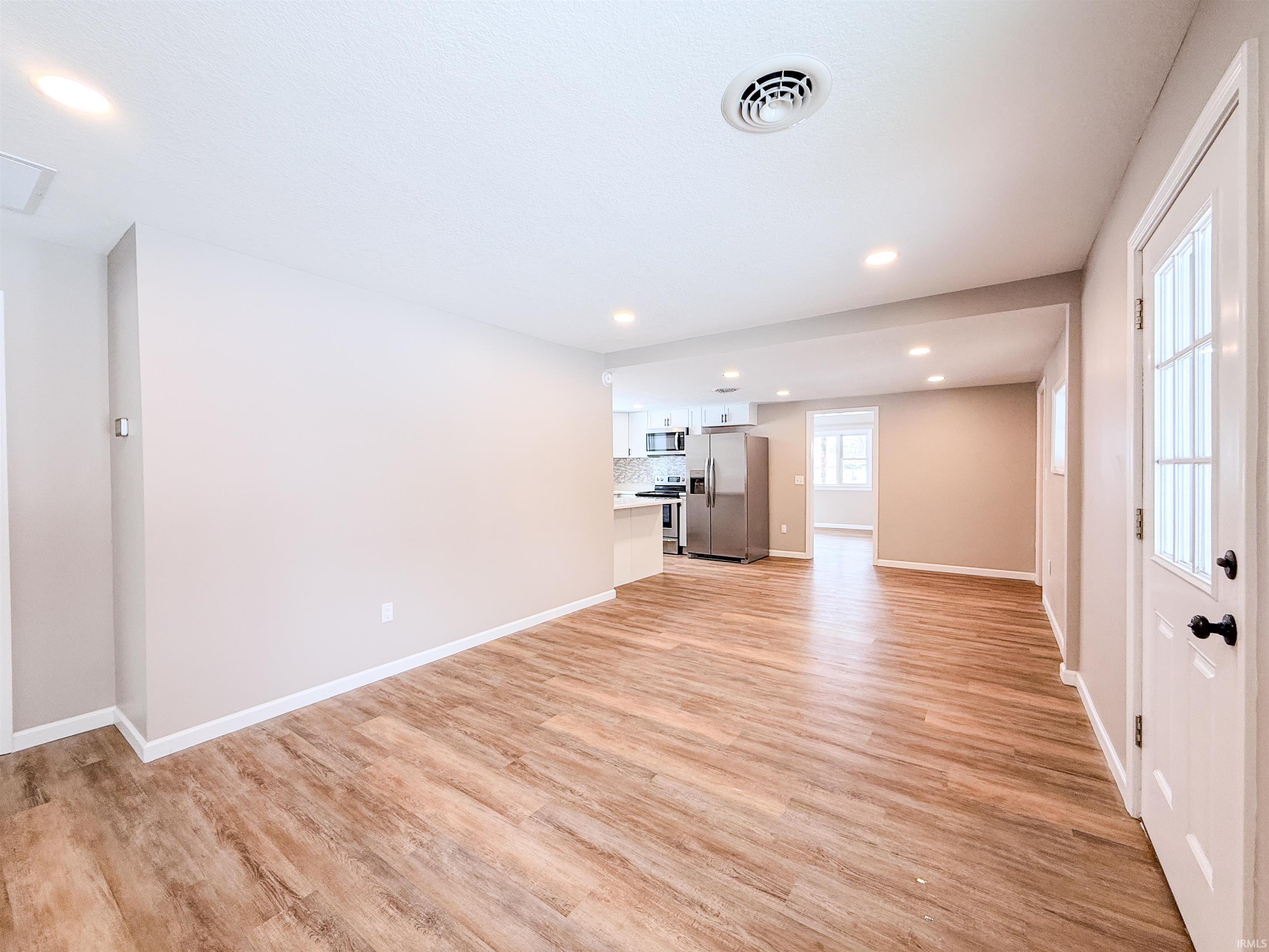 Unfurnished living room with light wood-style floors and recessed lighting