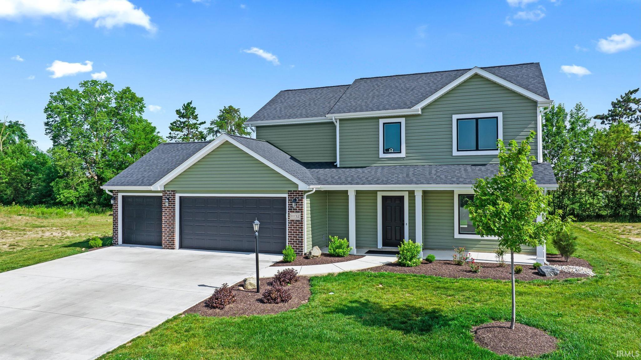 Contemporary two-story home featuring green siding and dark gray roofing