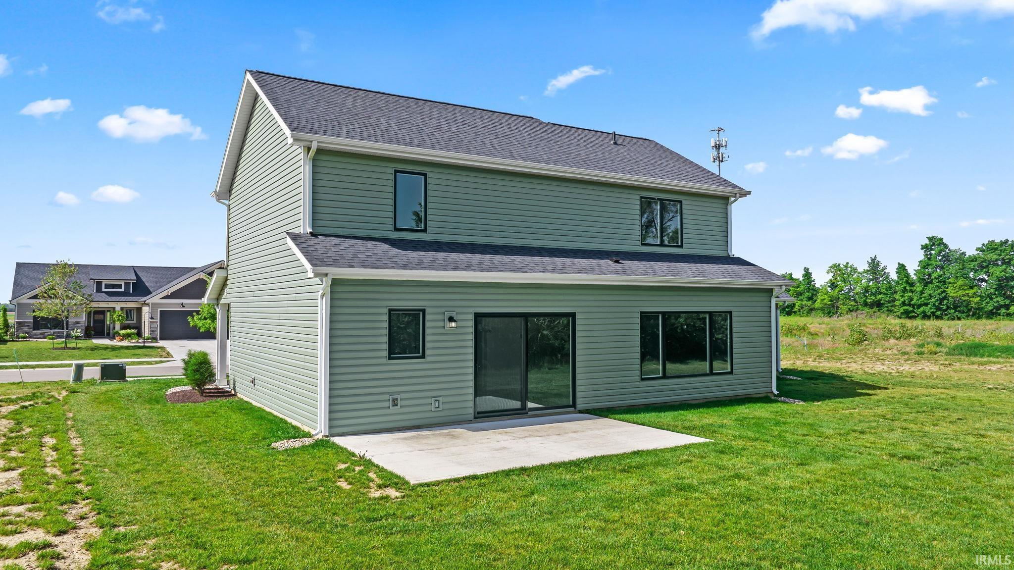 Two-story dwelling with light green siding and black-trimmed windows