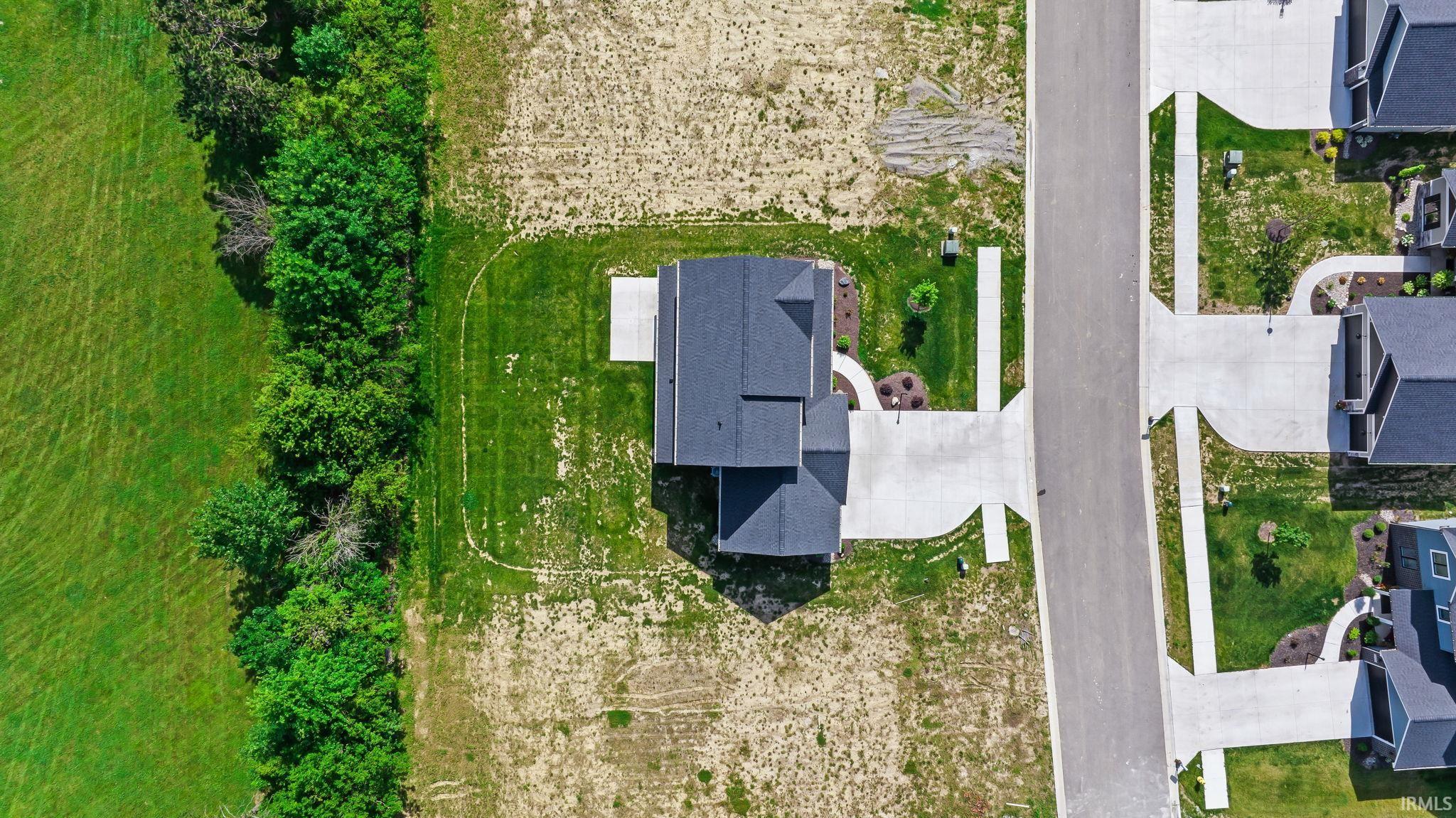 New construction residence featuring a dark shingle roof and concrete driveway