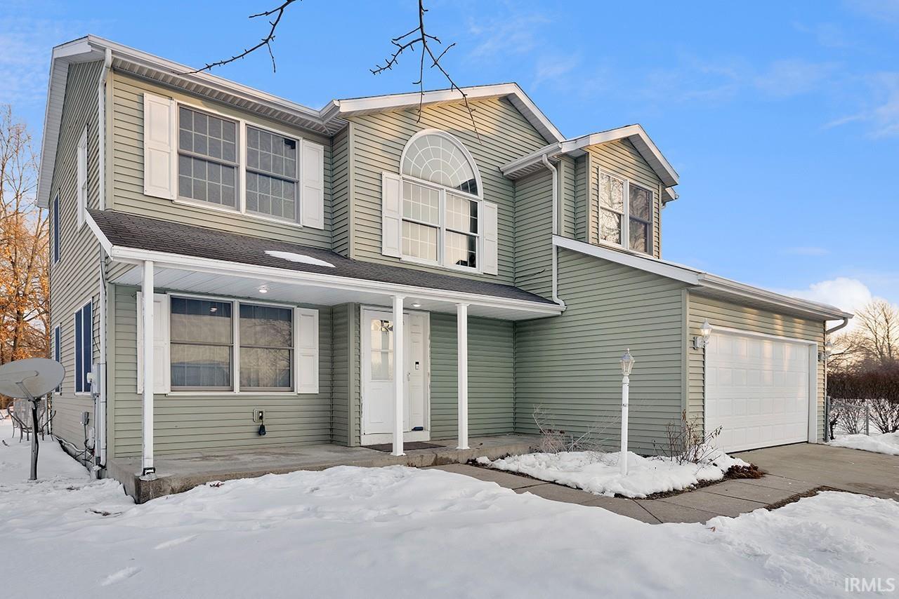 Traditional-style home featuring a porch and a garage