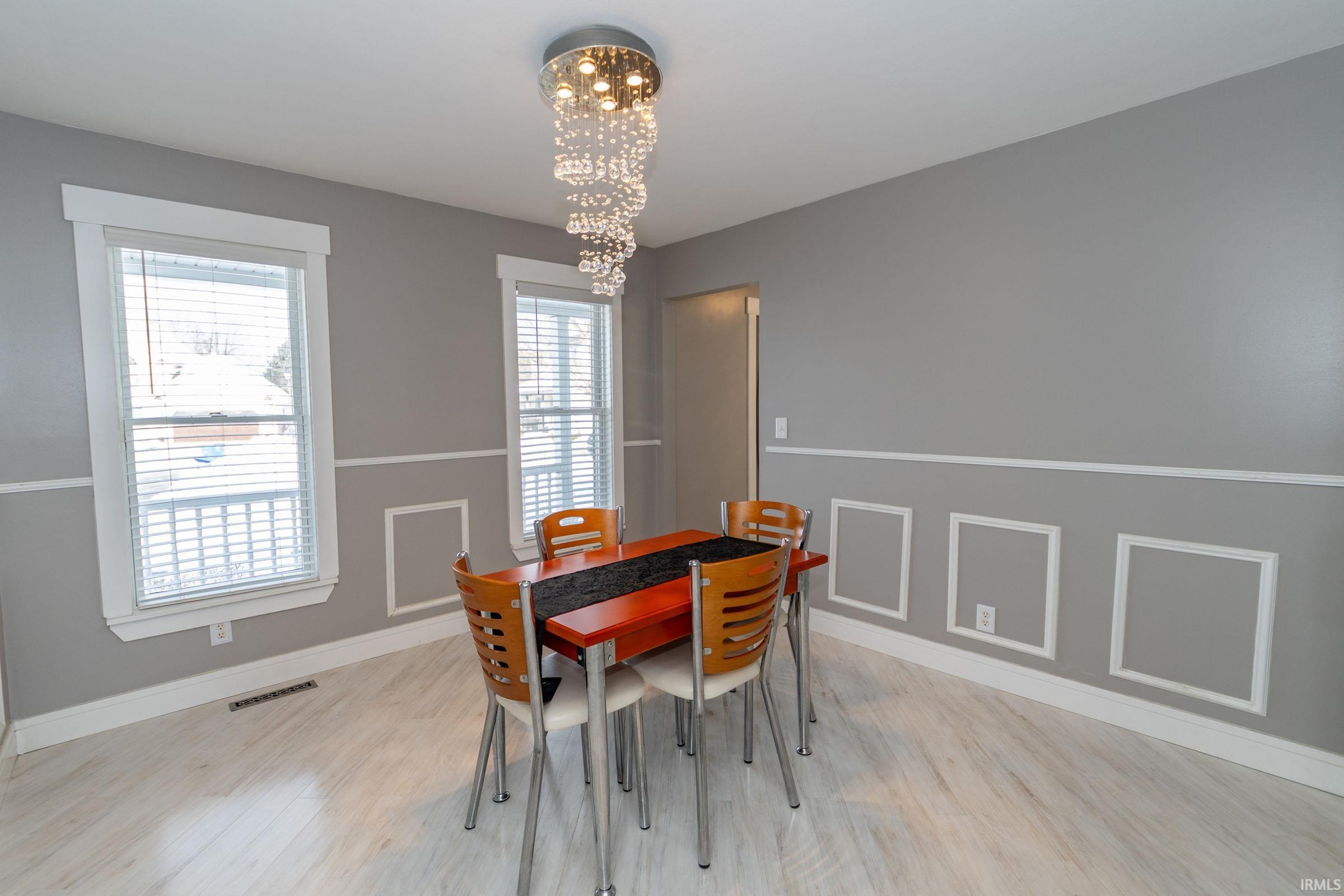 Dining room featuring light wood-style flooring and a chandelier