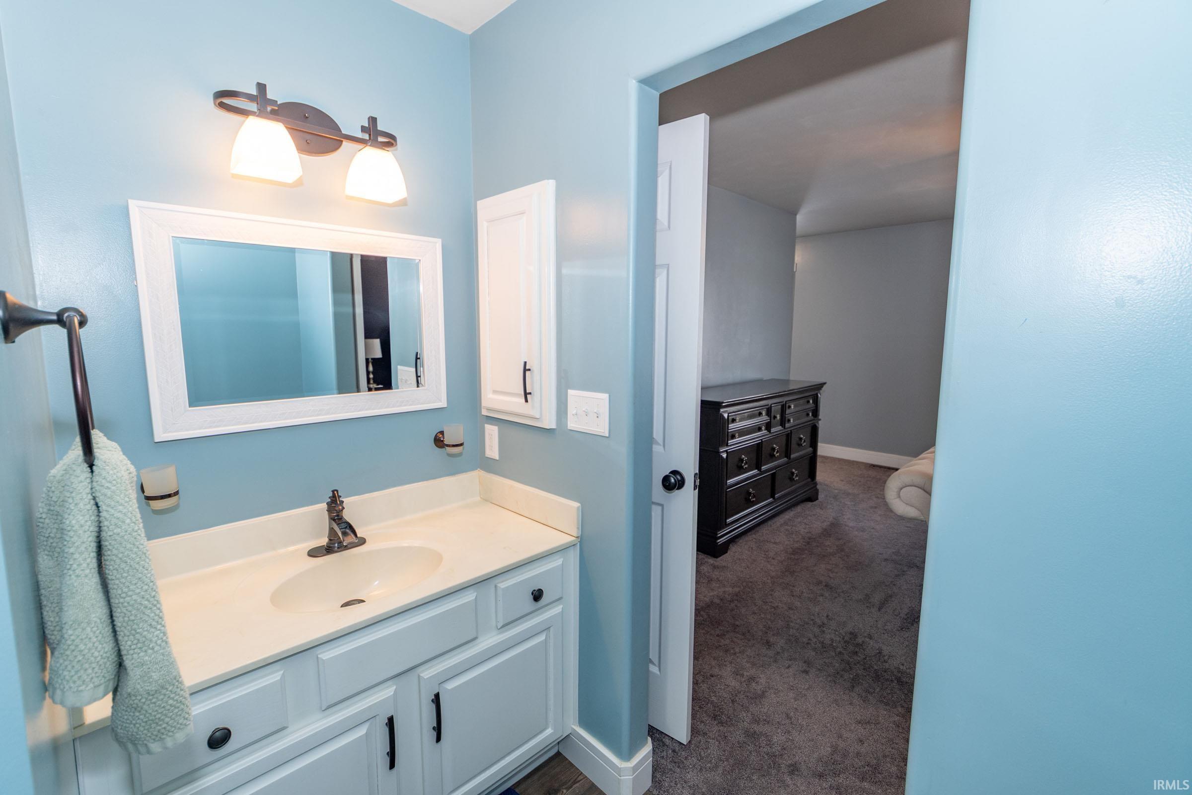 Bathroom featuring vanity and dark carpet