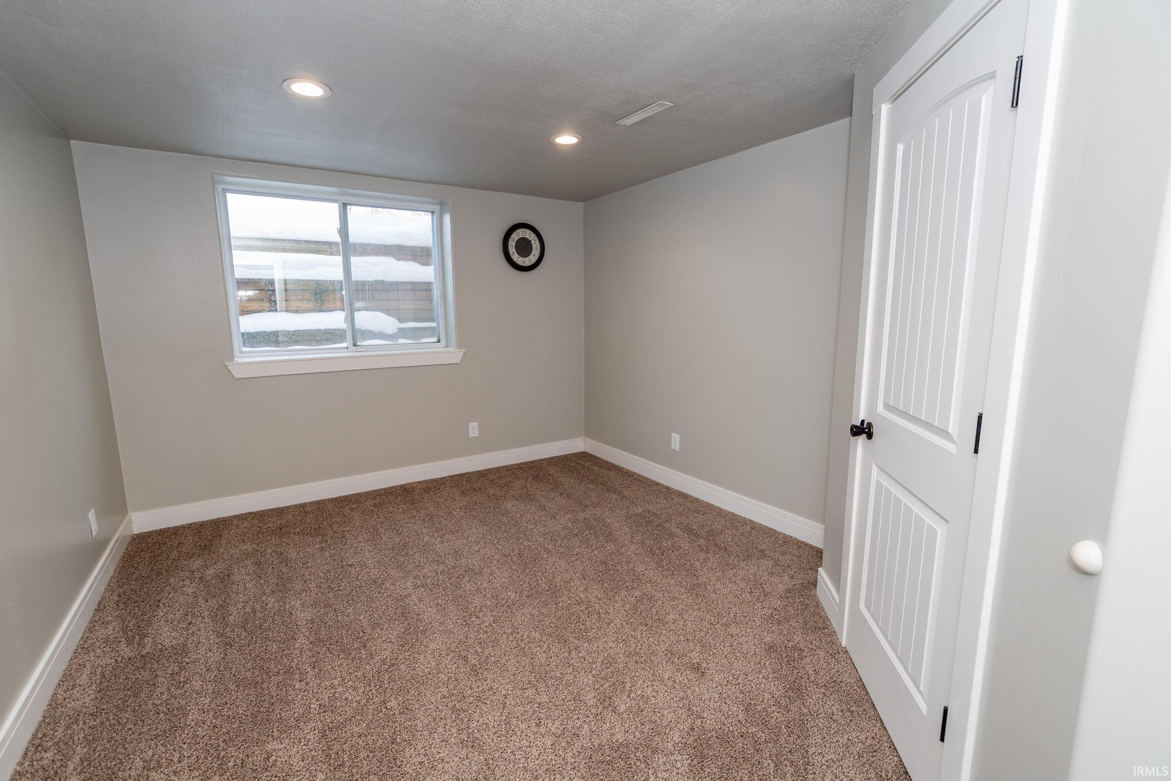 Spare room featuring light colored carpet and recessed lighting