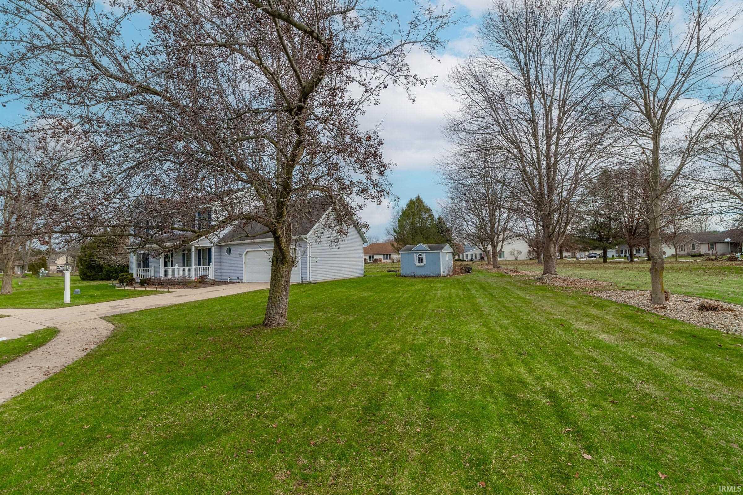 View of green lawn featuring driveway
