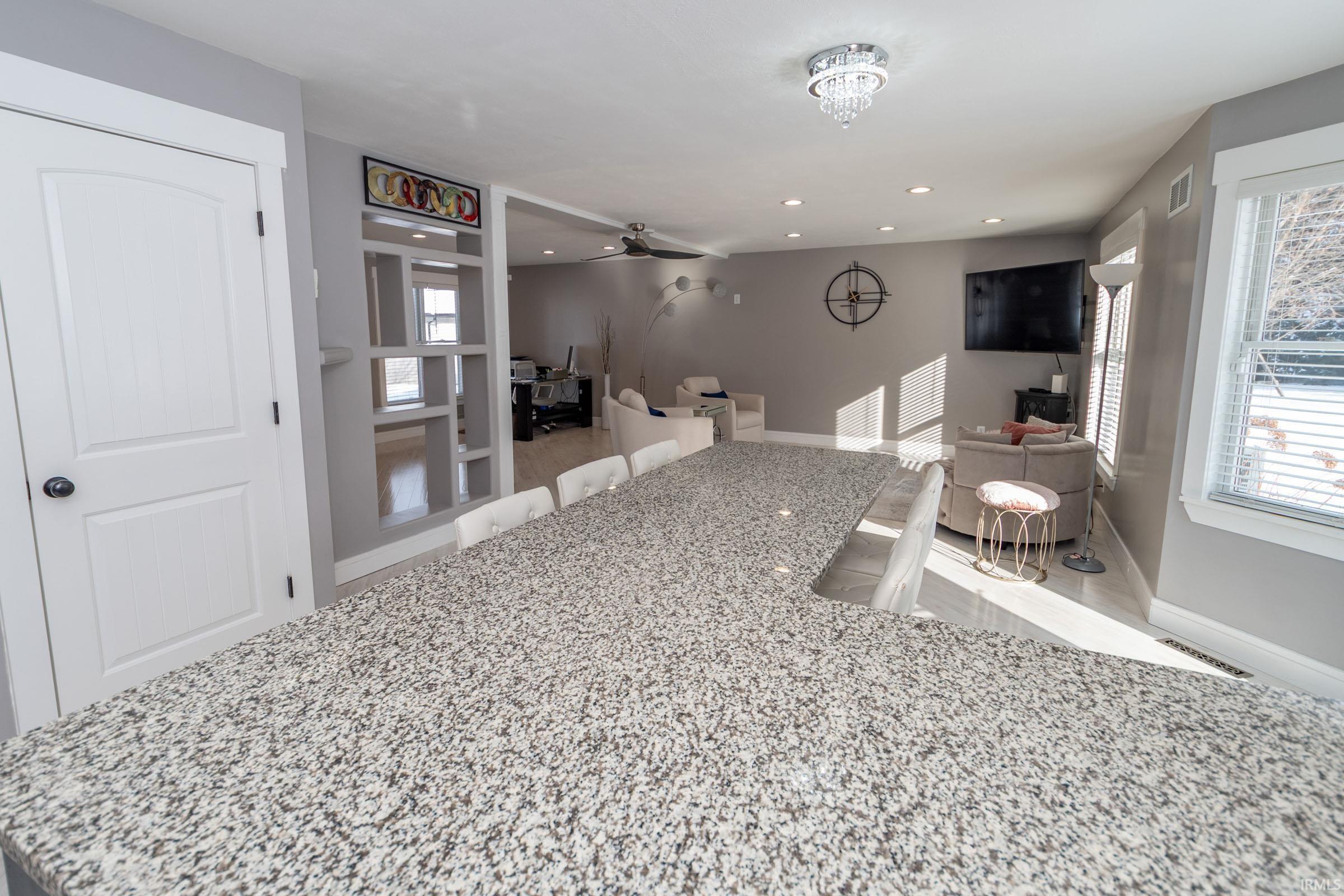 Kitchen featuring light stone counters, recessed lighting, and ceiling fan