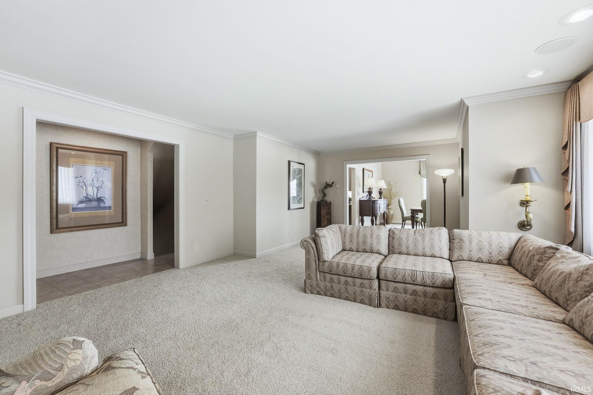Carpeted living room with crown molding