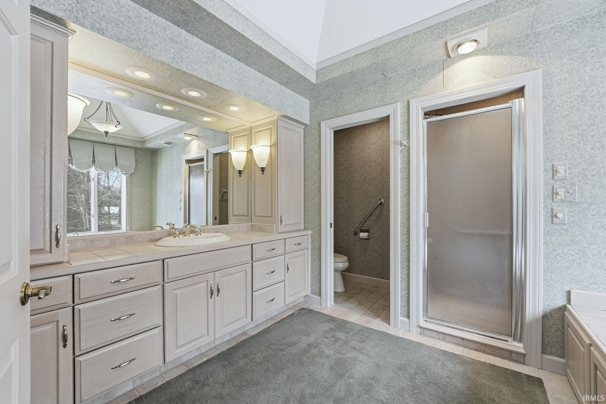 Full bathroom with vanity, ornamental molding, light tile patterned floors, a shower stall, and recessed lighting