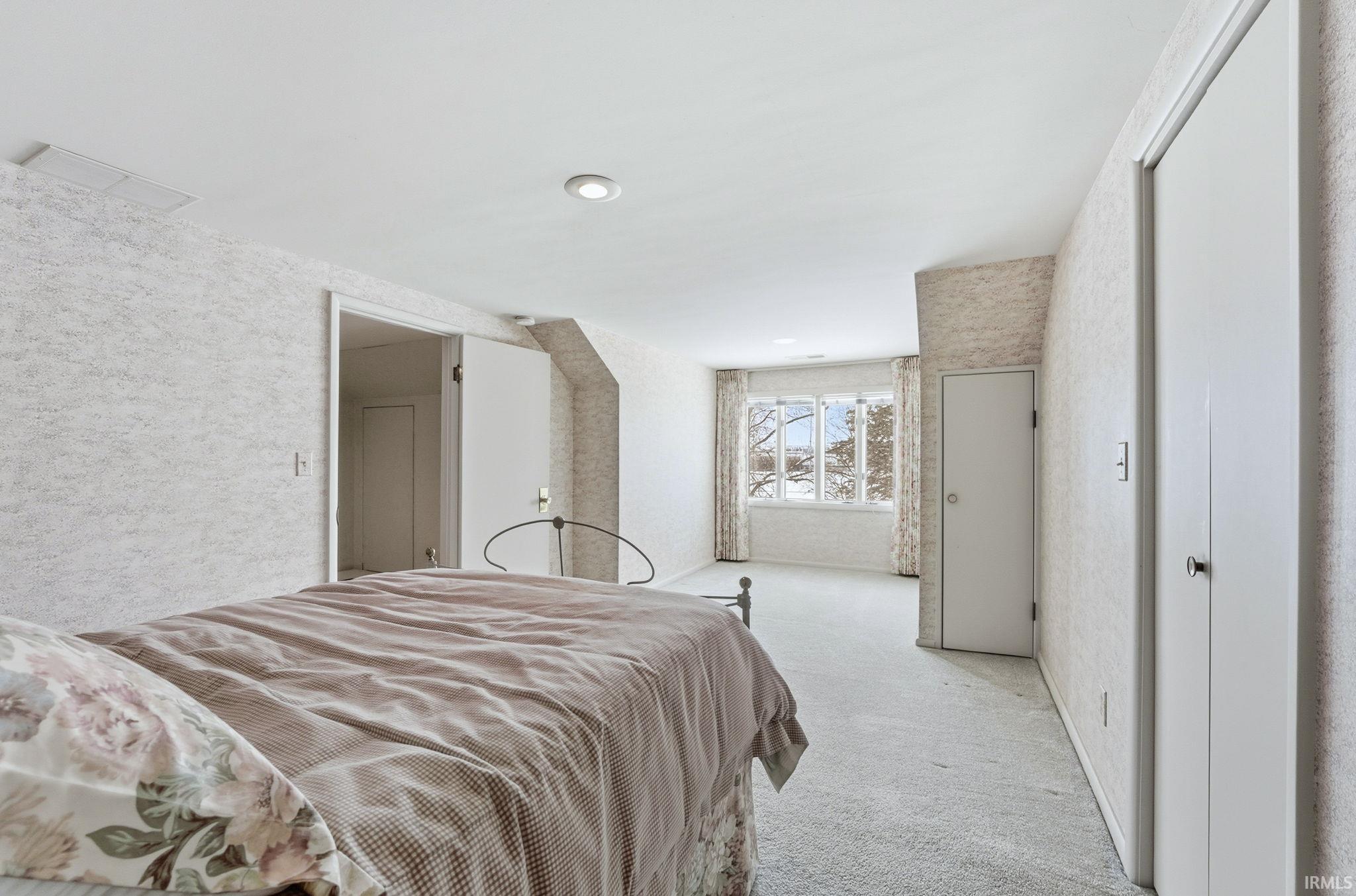 Carpeted bedroom featuring a textured wall